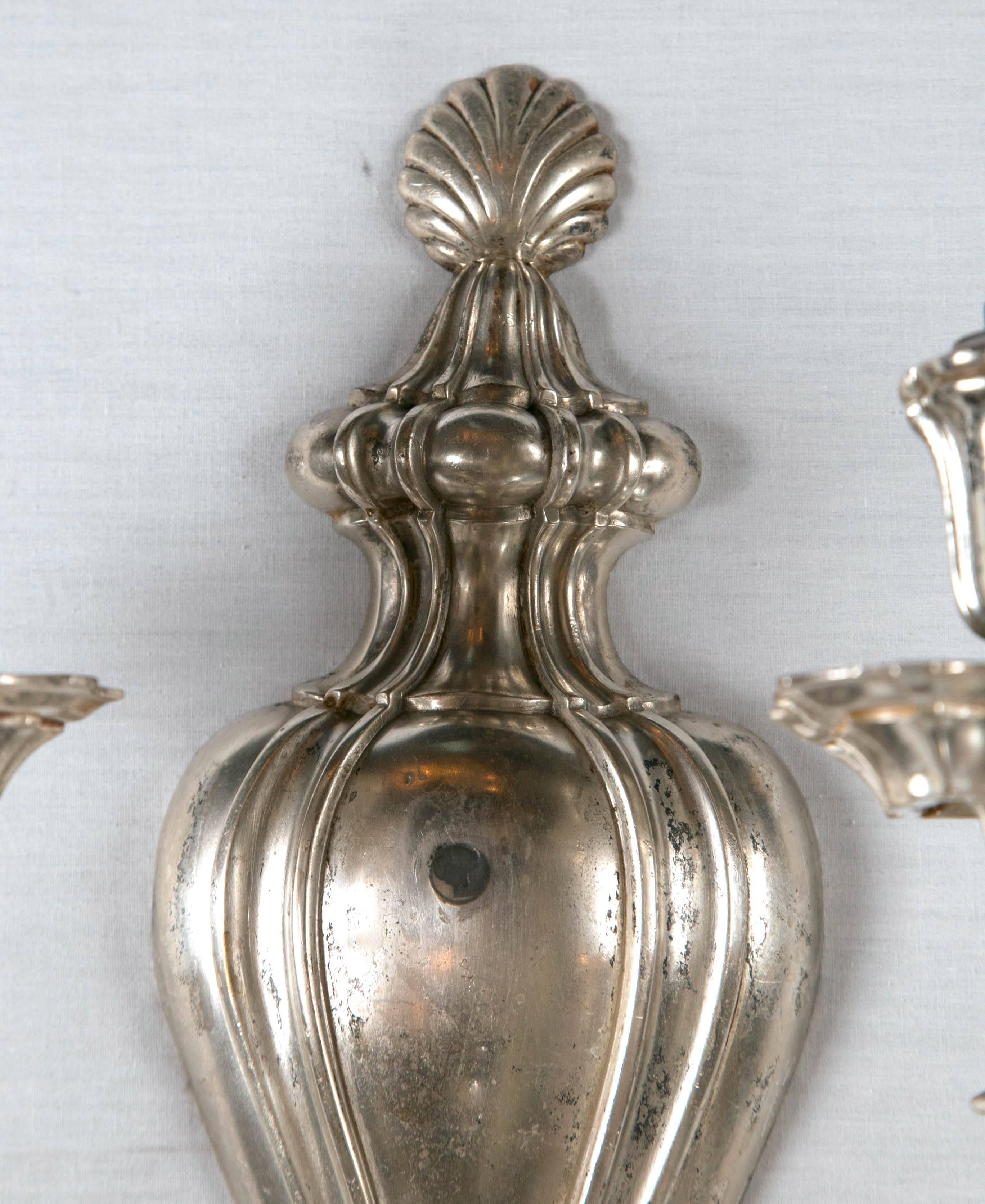 A set of 12 circa 1920s Caldwell silver plated sconces neoclassical style. Priced per pair.