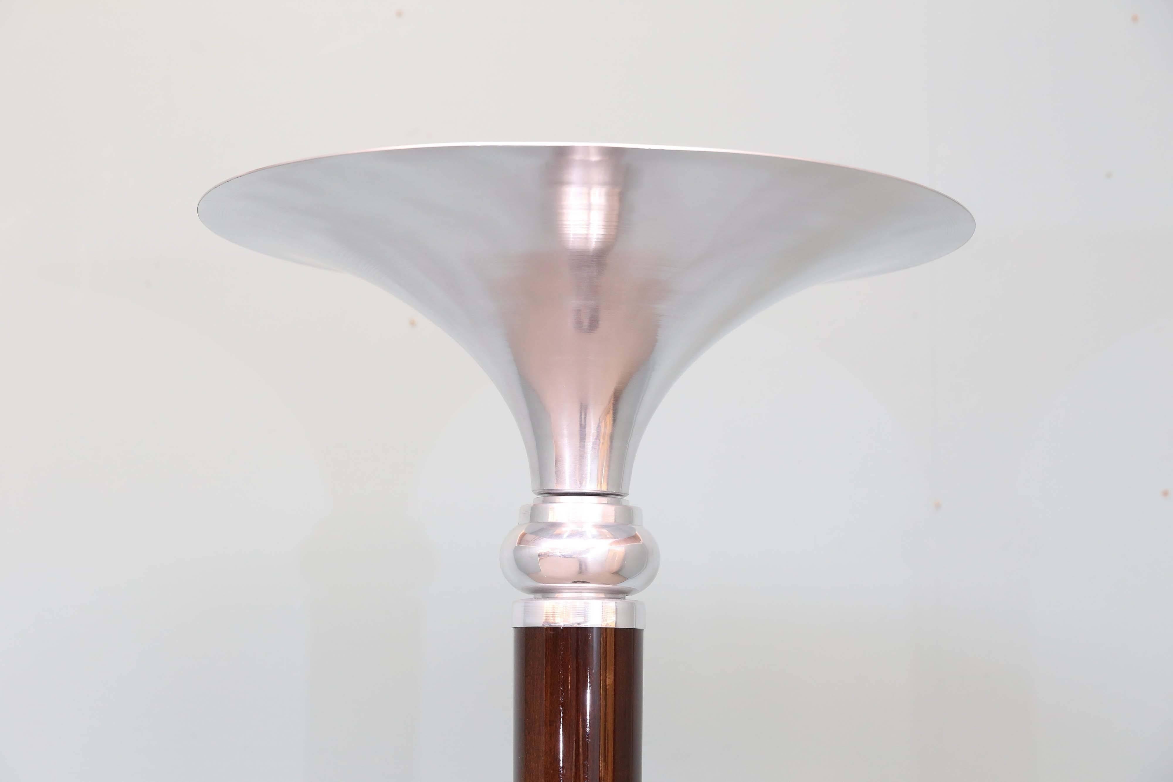 Funnel shape chrome lampshade is connected to the main pole and with a help of one chrome insert transfers to the wooden thick stabile base of the lamp. Due to the highly polished chrome, the light strongly irradiates and spreads through the space