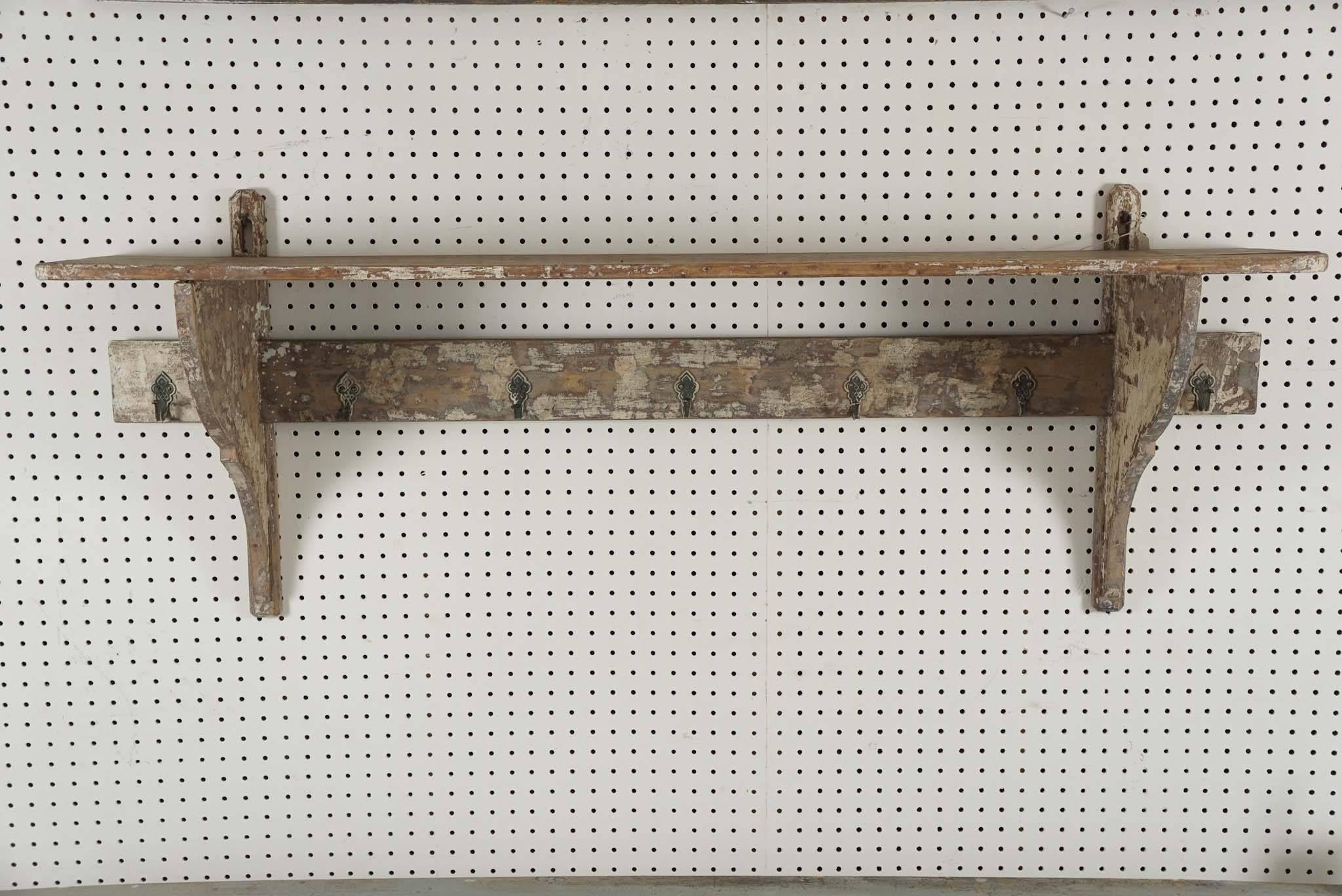 Olive green worn paint is the color on this French shelf with seven original hooks. Hang coats or display something on the shelf above. Perfect in a mudroom or kitchen.