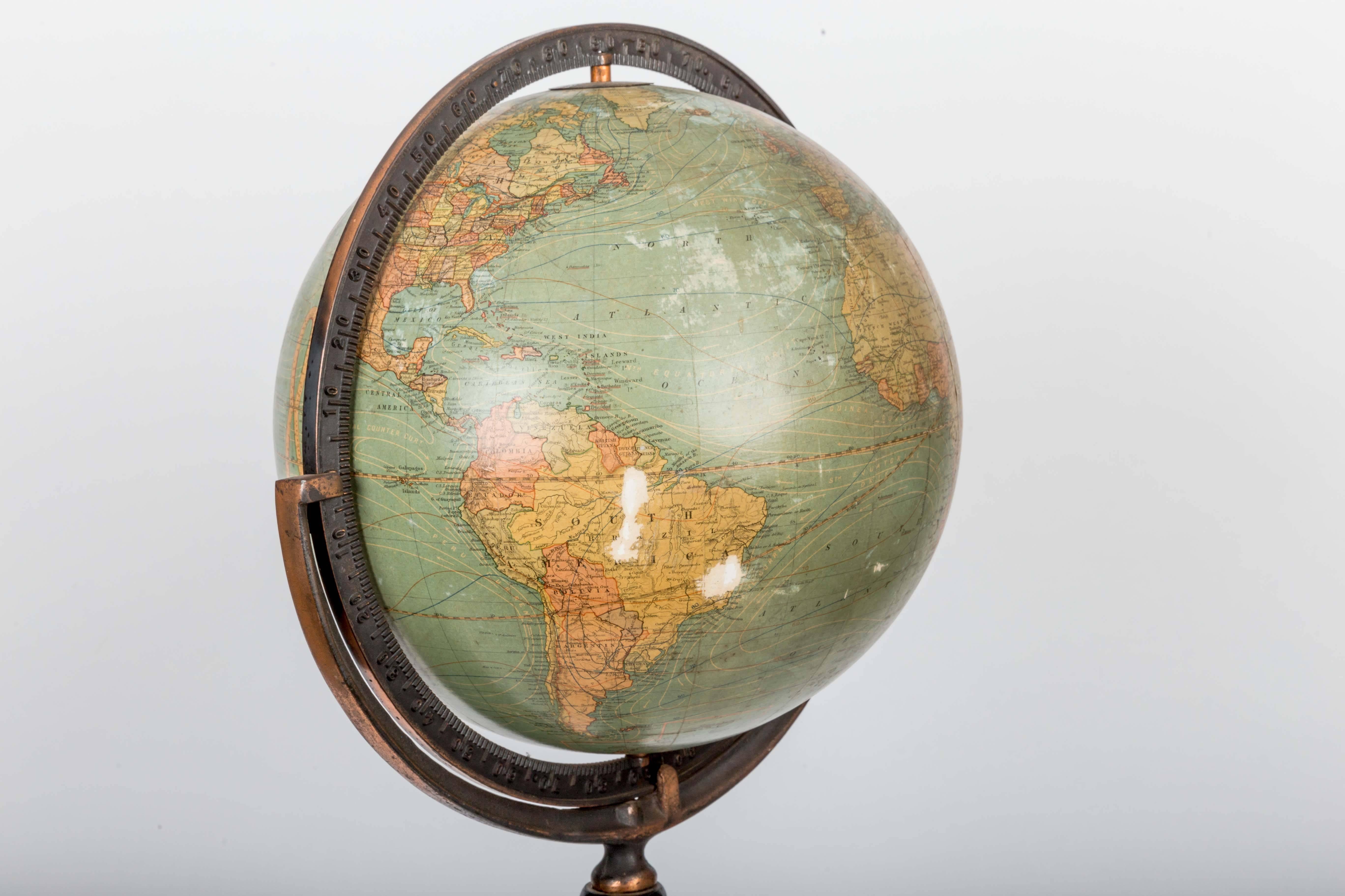 Early 20th century 12-inch terrestrial globe on turned walnut stand made by Kittinger Company of Buffalo NY.

It has a full ring meridian which is cradled in the stand, allowing the orb to slide/rotate, changing the axis angle. The meridian and