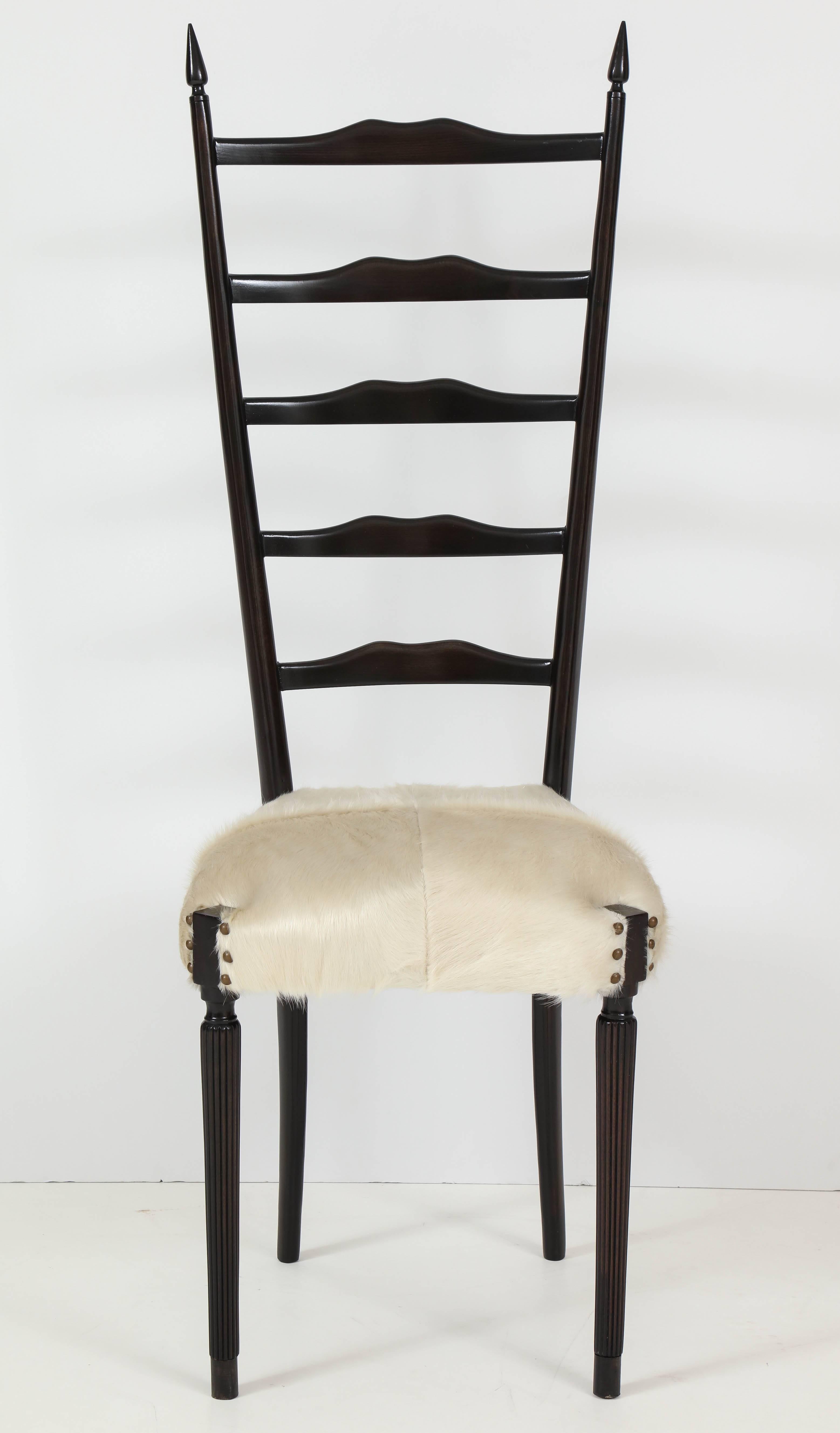 Pair of Italian Mid-Century ebonized walnut framed side chairs with white calf skin upholstery. Chairs have been mint restored with retied springs, foam and webbing and feature bone white calf upholstery. Chairs have fluted front legs and back have