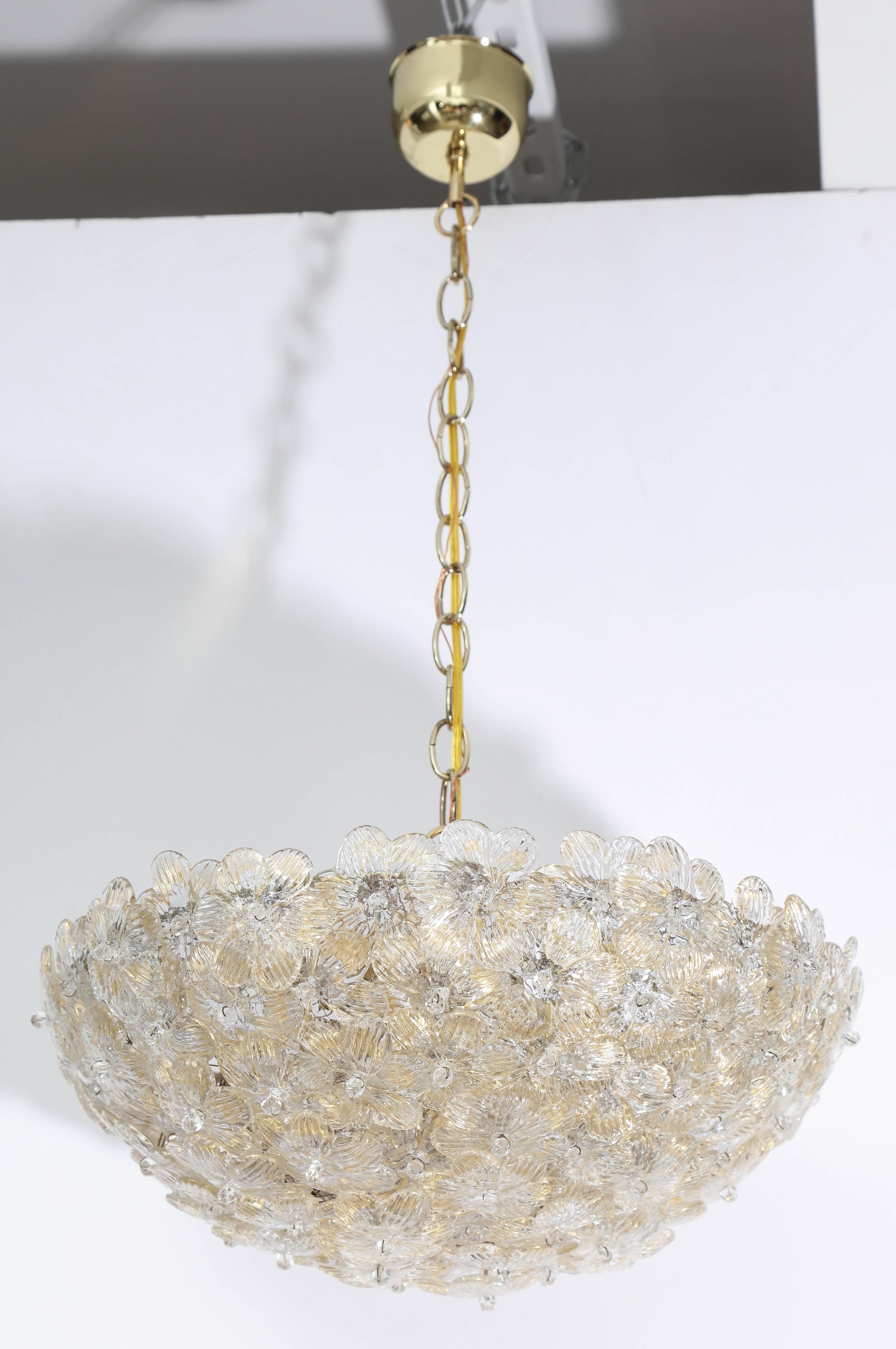 Italian Mid-Century classic chandelier composed of overlapping Murano glass flower elements with a slight gold sprinkling throughout the glass, suspended from a brass chain and canopy. Uses three bubs, newly rewired for US standards. Chandelier