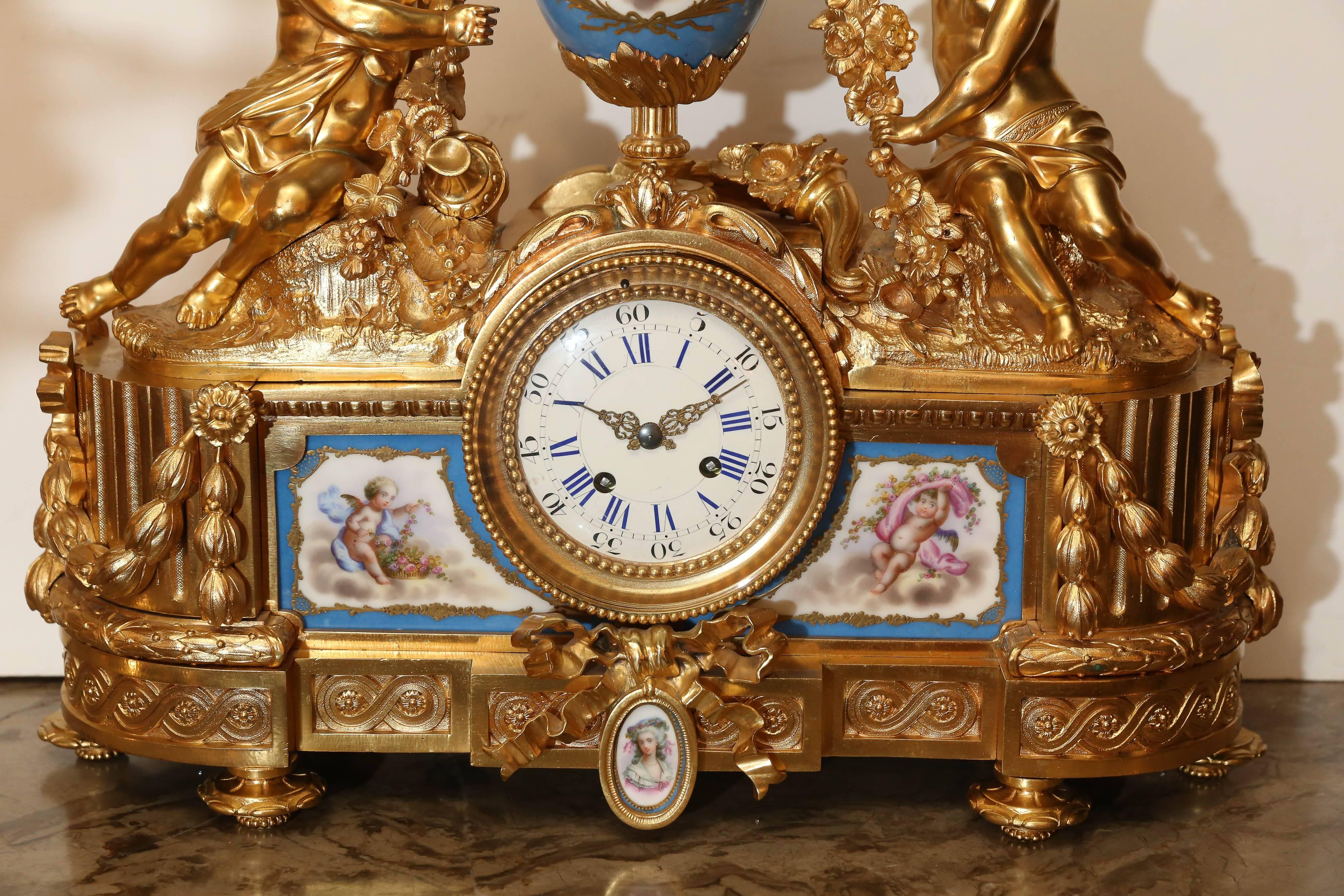 Large and exquisite bronze doré clock with large putti holding a garland
of flowers over a porcelain painted mounted above French clock.