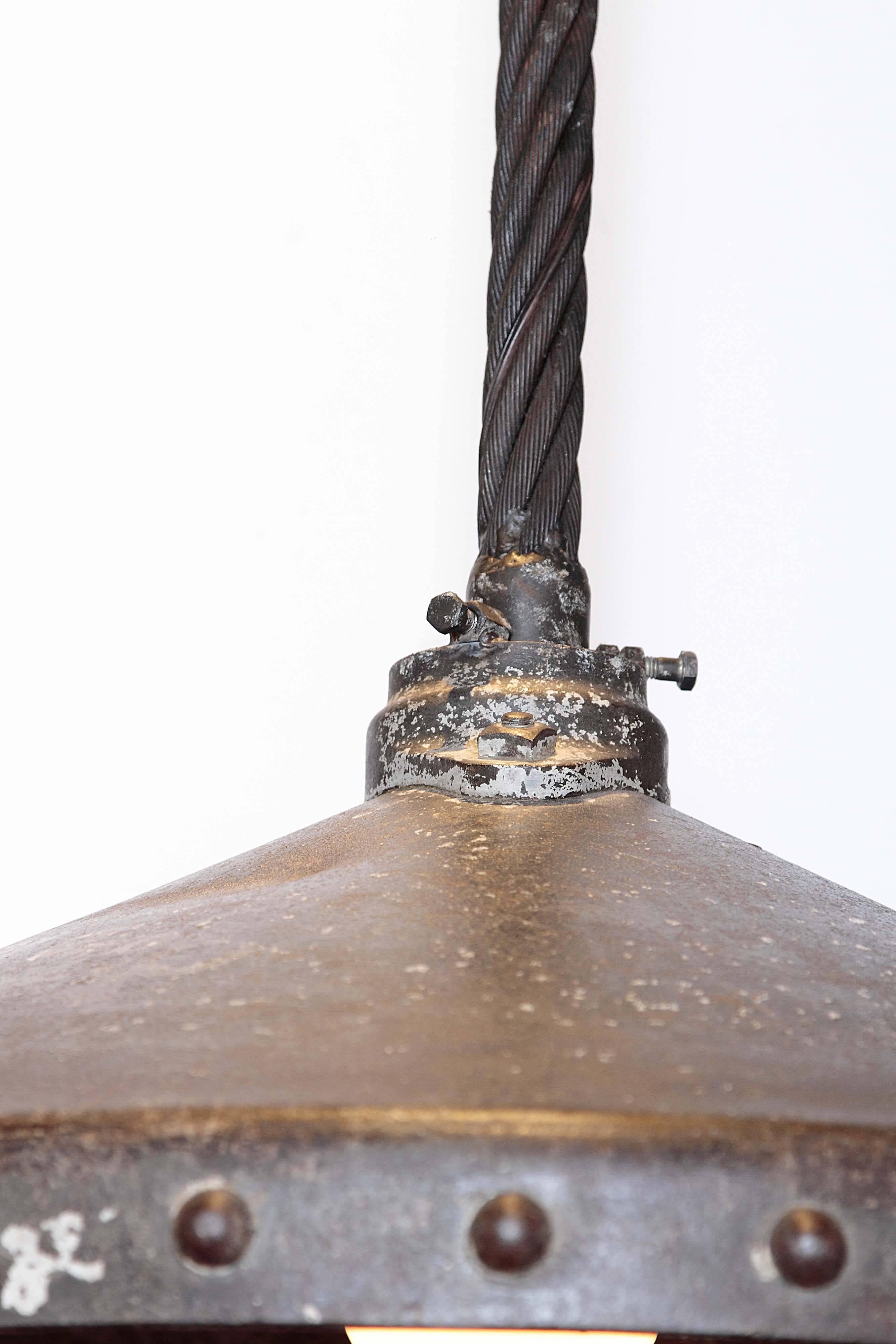 Industrial large iron dome light. Cast iron with steel wire. 

This oversized cast iron light cover reclaimed from a demolished, 1950s era Philadelphia stamping factory. 
 Originally, a large electrical transformer sat atop the cast iron cover.