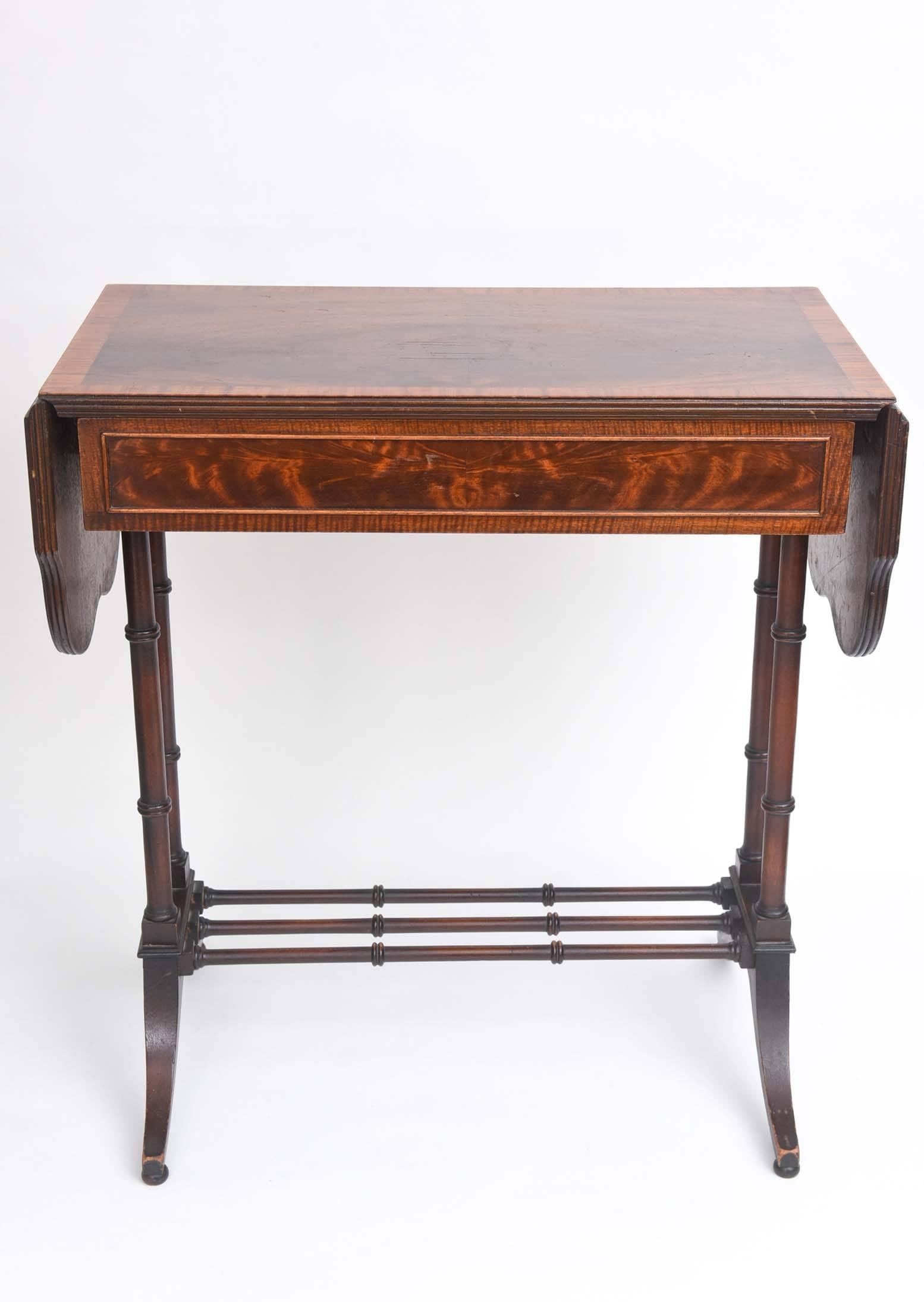 An interesting antique and versatile table with sides that extend the length. Nicely turned legs and great wood veneers and inlay. Retaining its original label from the fine cabinet and furniture firm of: Johnson-Handley Grand Rapids Michigan.
