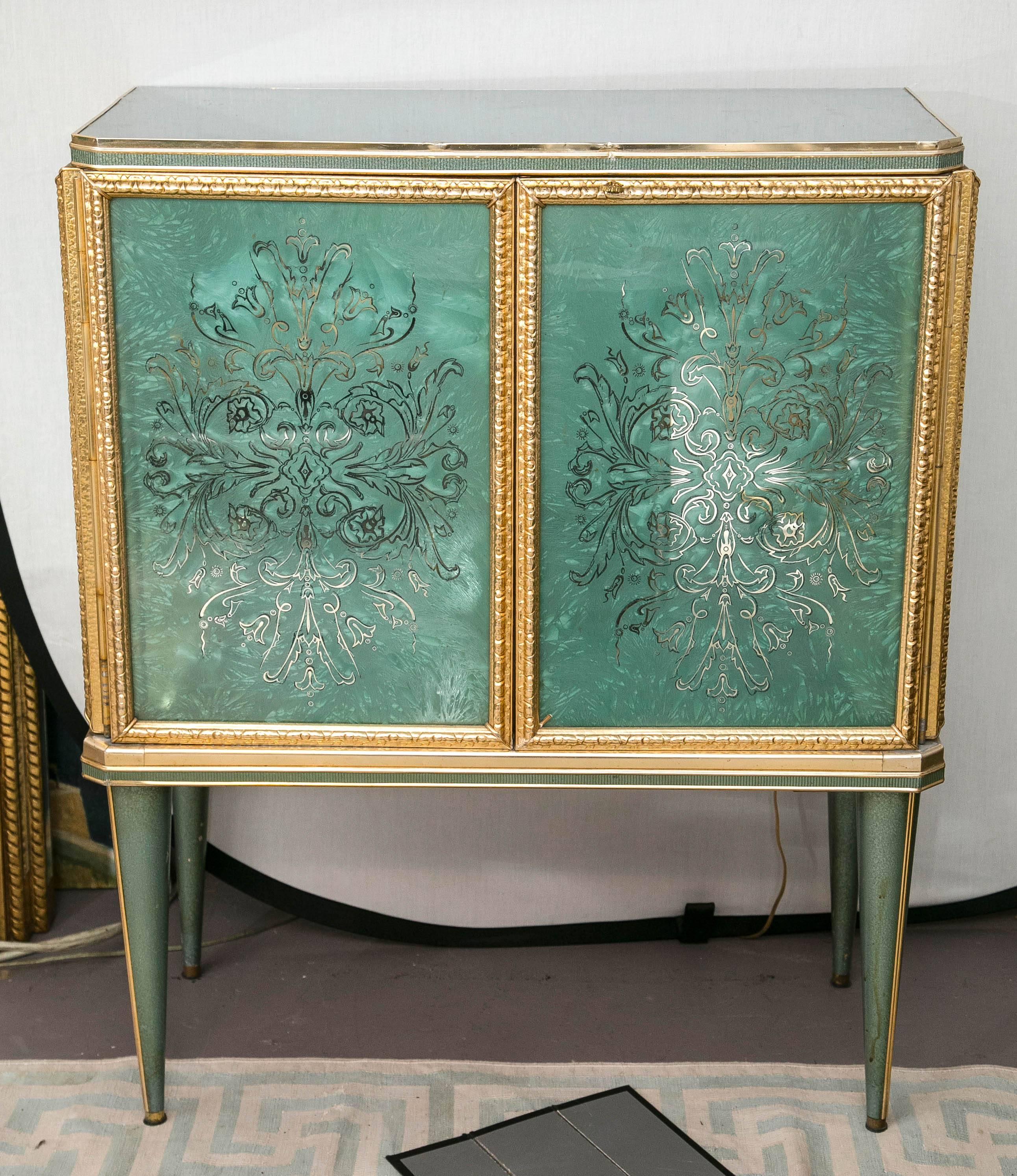 A charming green glass cabinet with etched doors and sides trimmed with bronze ormolu. Wooden legs with a metal trim.