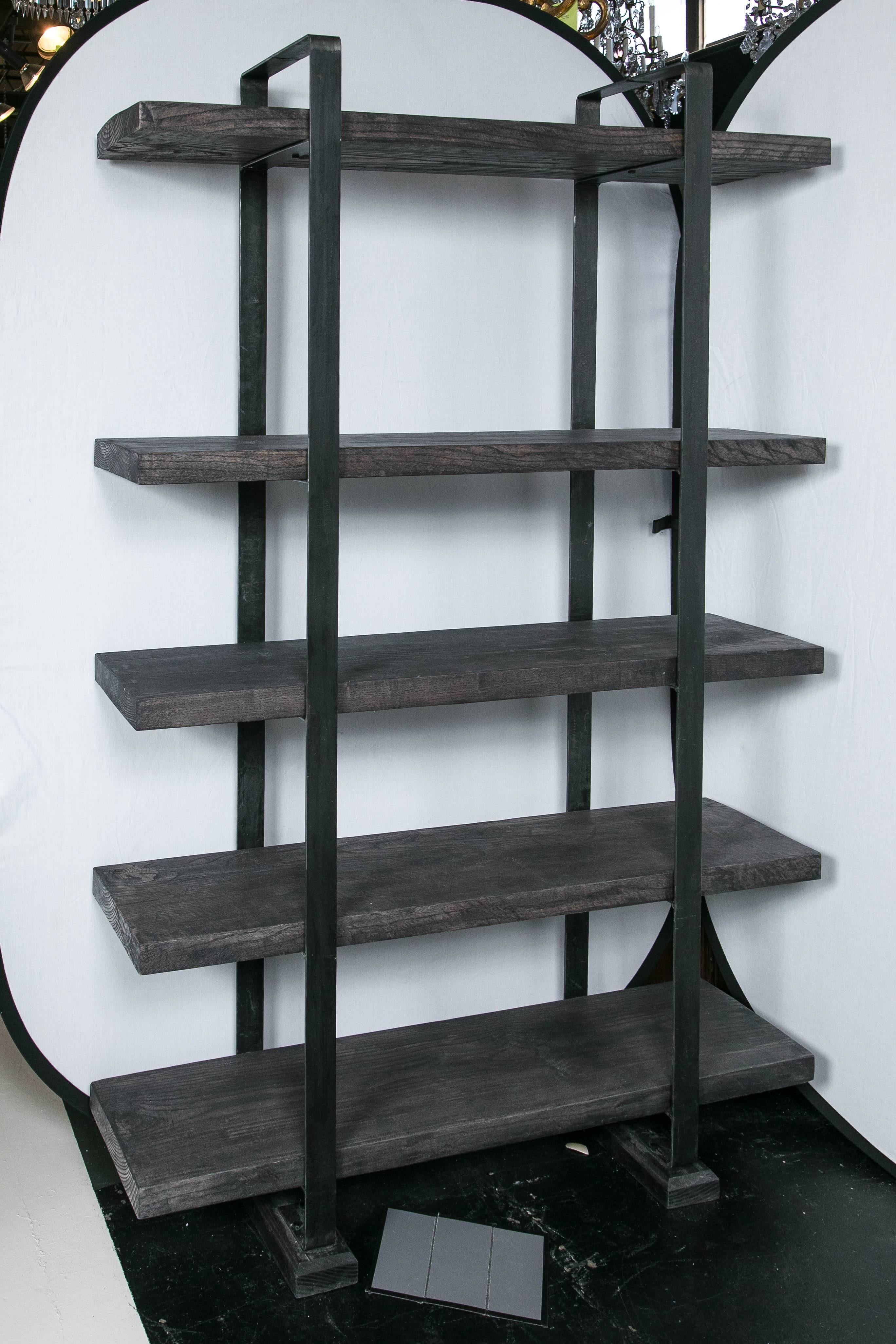 Five-tiered shelf made from thick ash planking and welded steel bands as supports. The shelves come from an antique saw mill, aged and stained. The two inch wide frame on each end is a welded 18 inch steel bent to form an arch over the top.