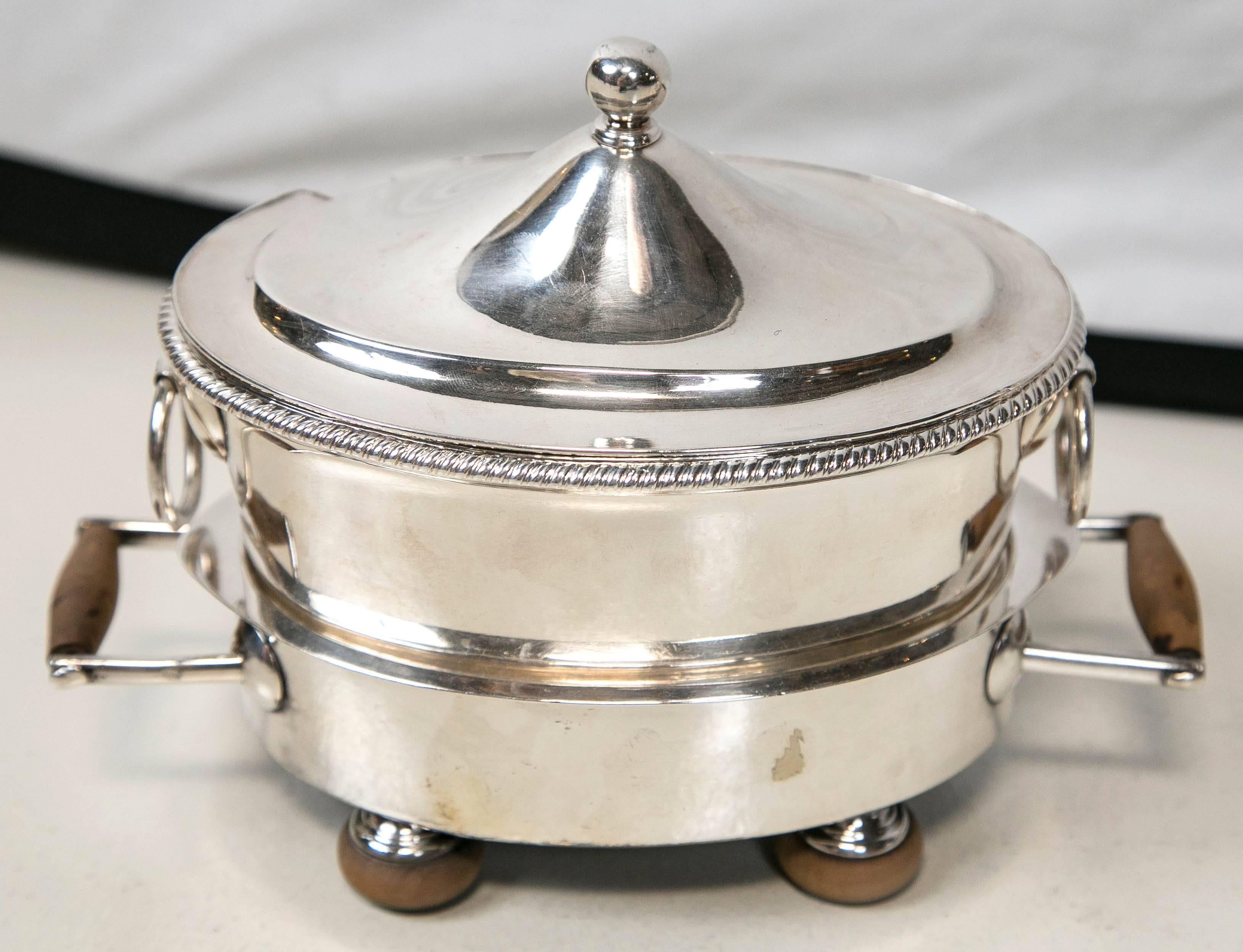 A pair of English Sheffield tureens with armorial shield engravings and bun feet.