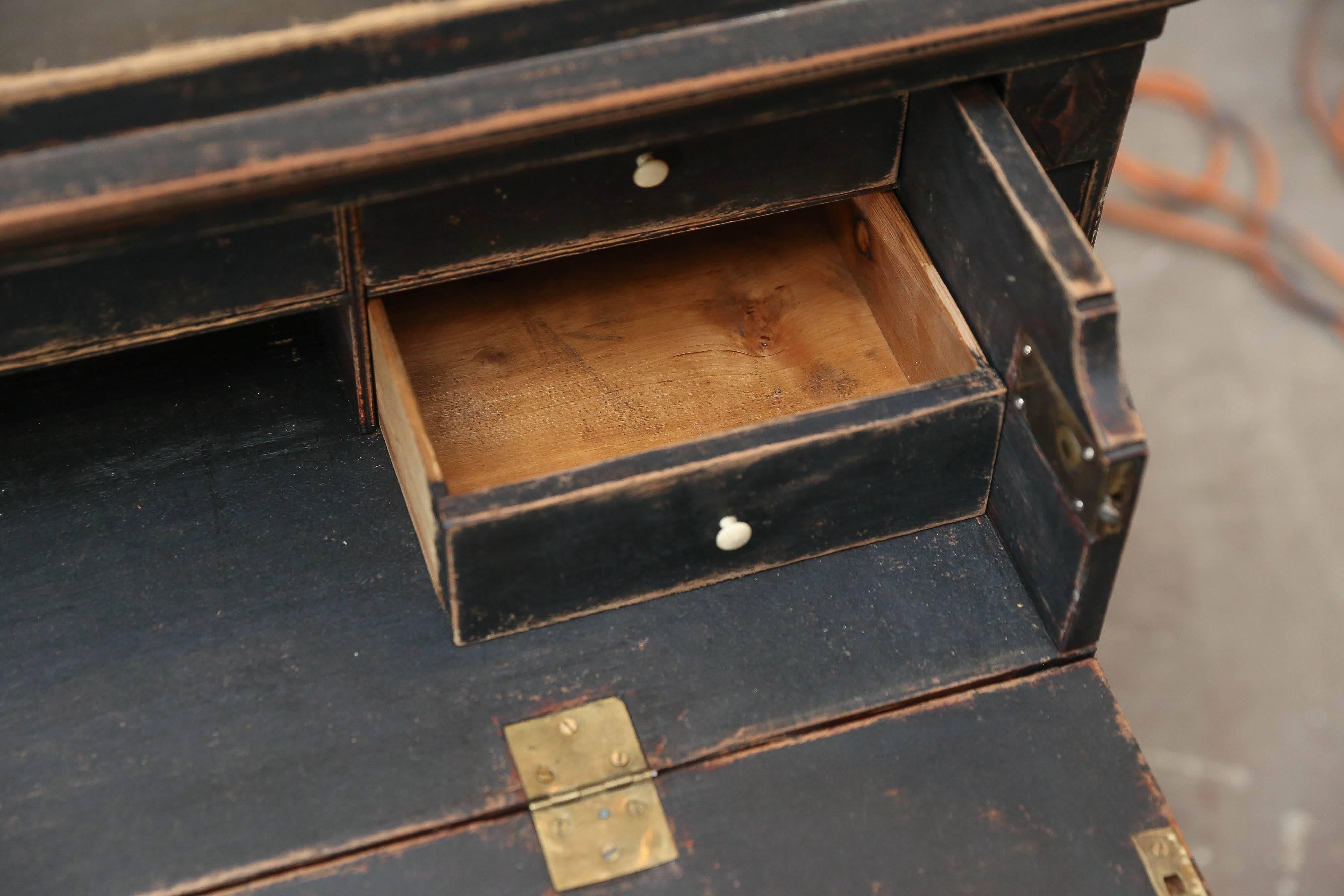 Adorable black painted chest that has a drop front top drawer to become a secretary with gold brass hardware. Great for a bedside chest or focal point piece. It has clean lines for modern or tradition design.