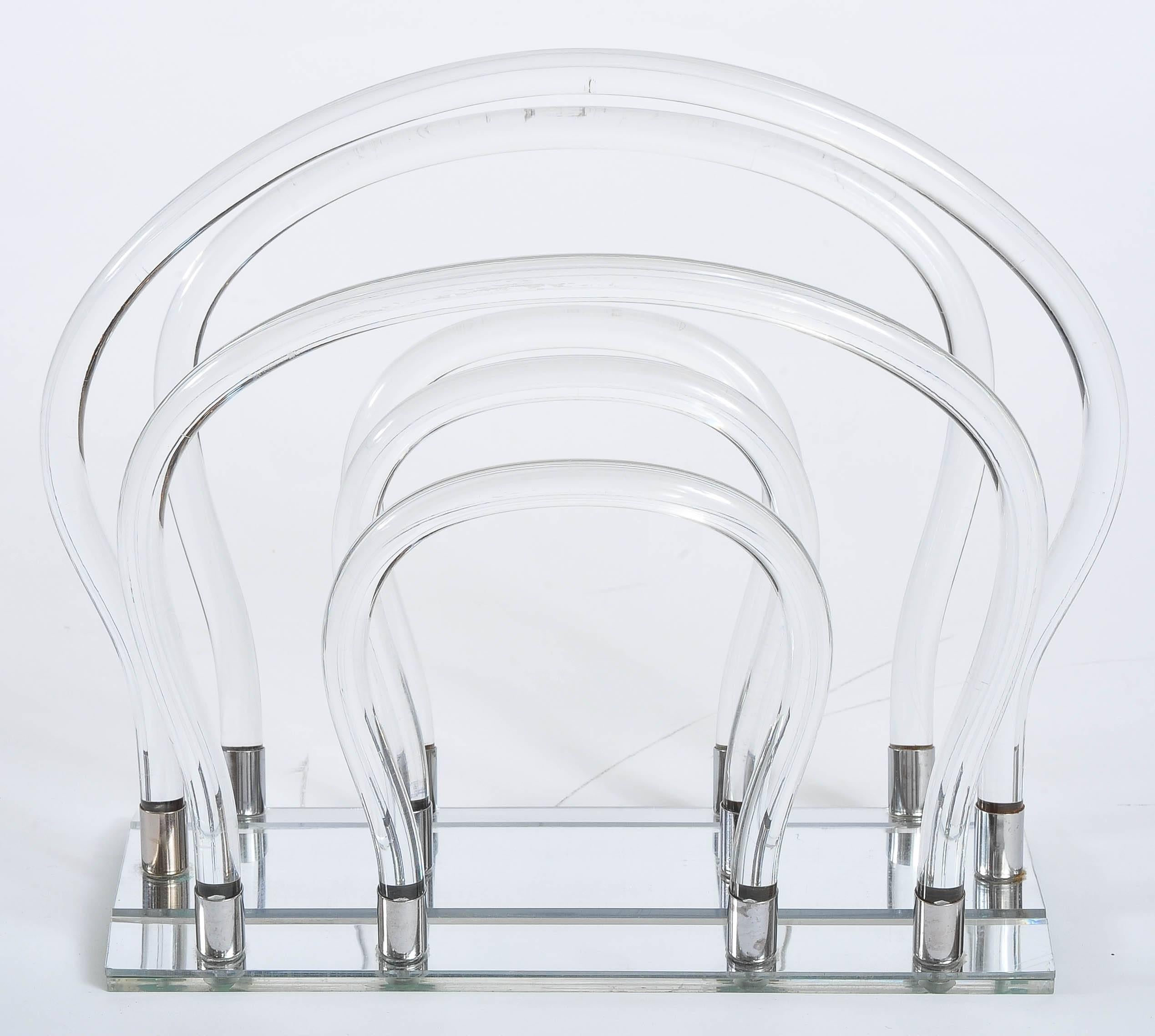 Sculptural magazine rack with mirrored base, 12 chrome holders and six curved Lucite tubes.

 