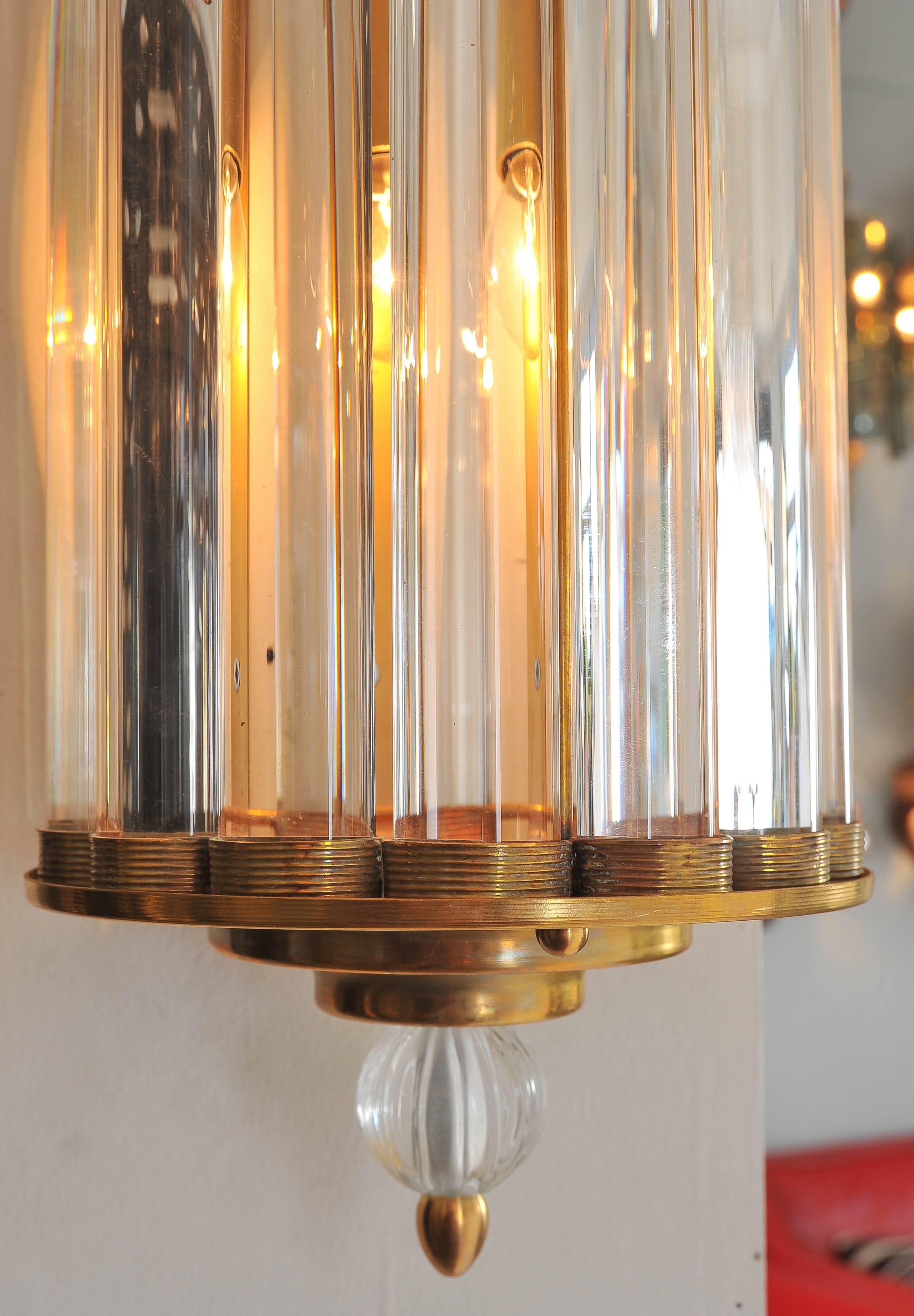 Italian wall lights in the style of Venini, each with 12 crystal rods fitted at the top and bottom by two stepped, brass, semicircular supports finished by crystal ball finials. 

Four available.