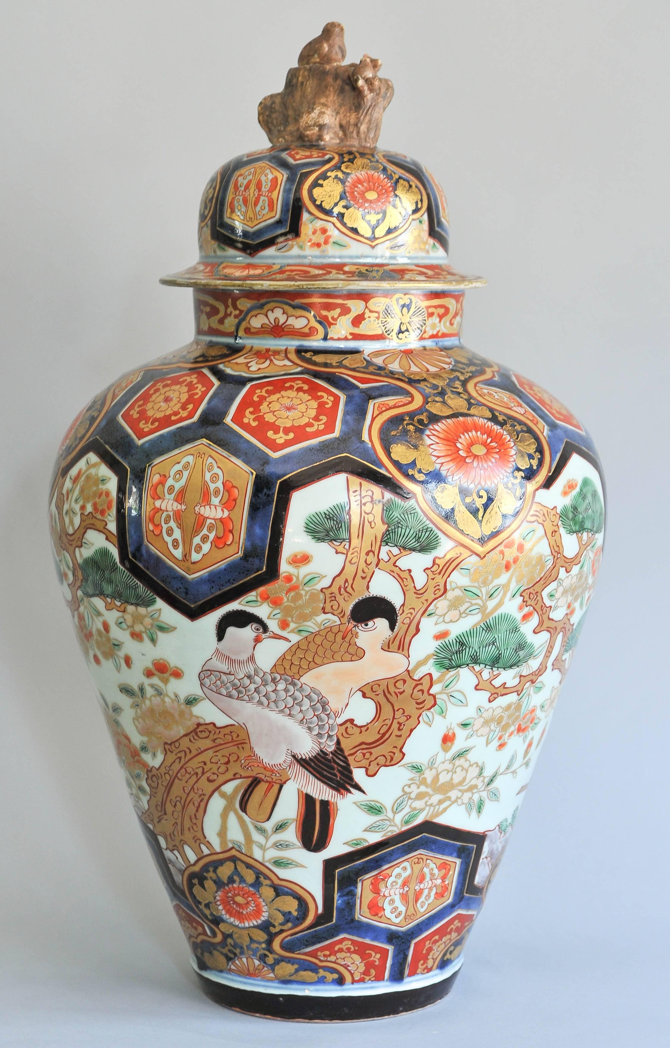This large Japanese Imari vase, dating from circa 1700, features an unusual decoration depicting two large quails perching on a tree branch on a blue background with hexagons panels depicting butterflies and stylized flowers.
The lid depicting same