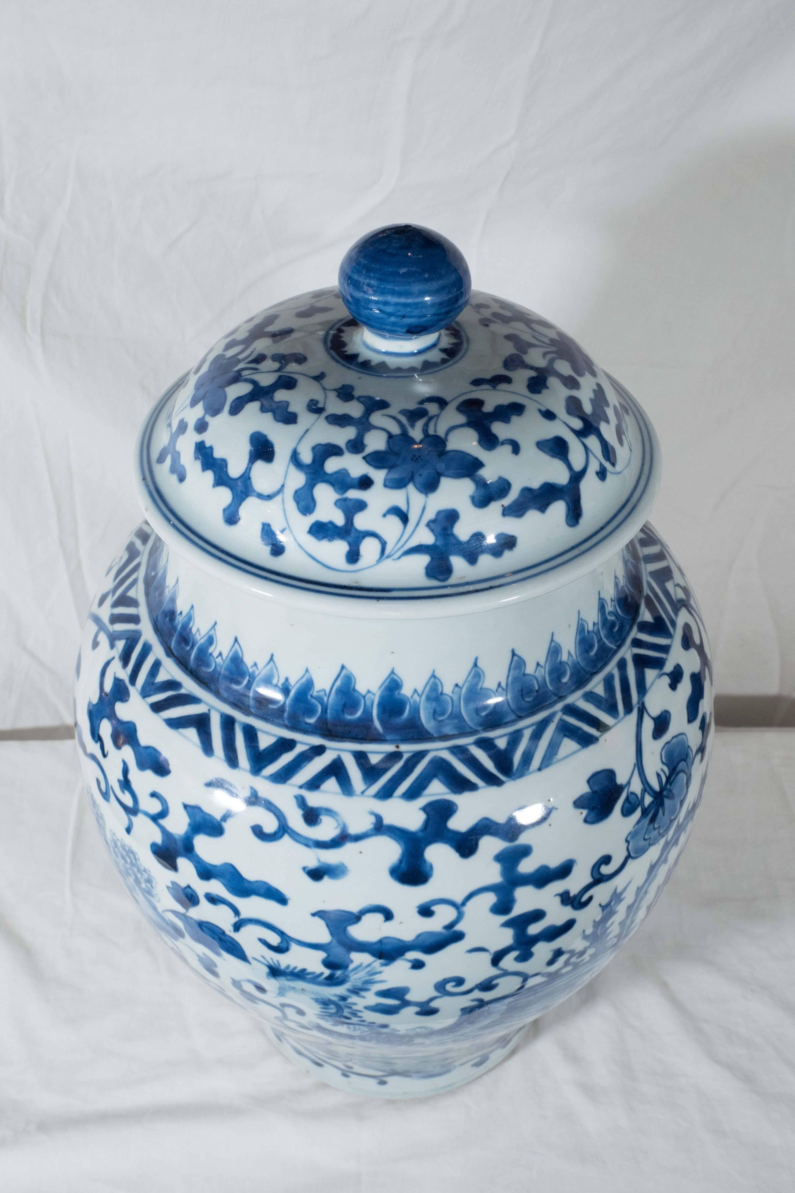 A pair of 18th century, Qianlong, Chinese porcelain covered jars painted in underglaze cobalt blue. Decorated with dense foliage with large peonies and phoenix (his head is seen on the right side in the main image). In Chinese tradition the phoenix