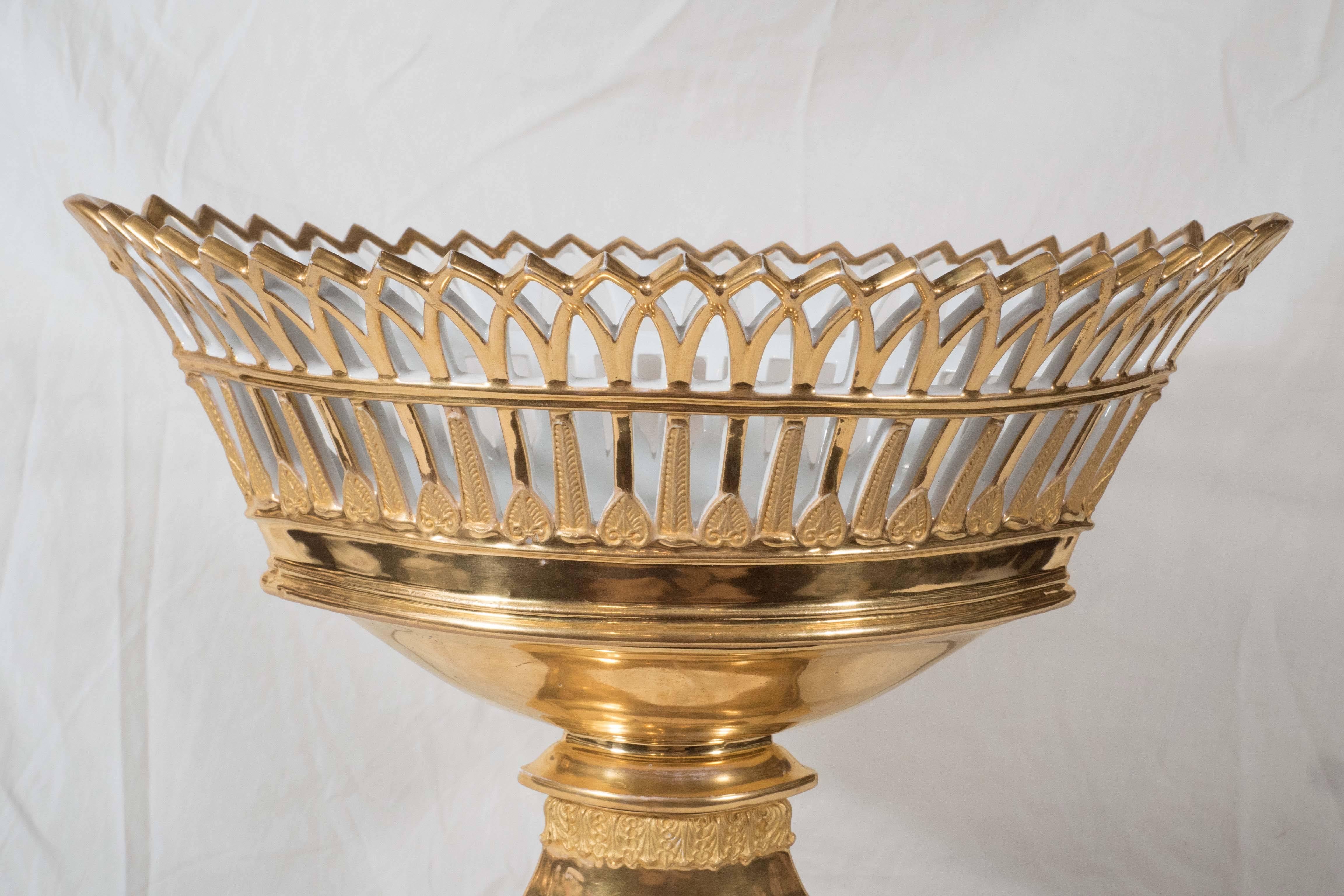 An elegant Paris porcelain pierced basket (corbeille) oval shaped, lavishly gilded, and decorated with bands of acanthus and anthemion leaves. The rectangular base is decorated with a lion's head and acanthus leaves.
 