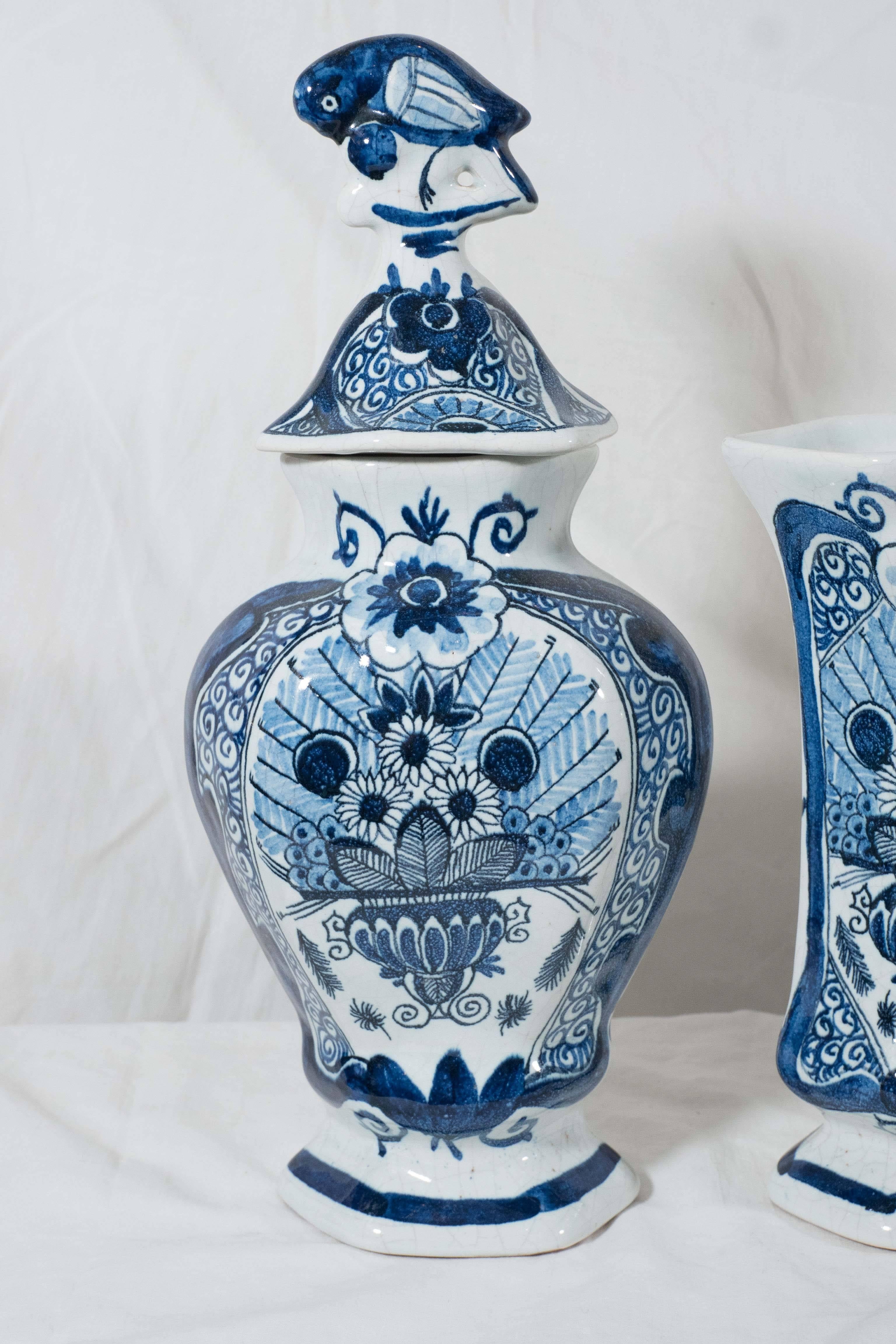 A blue and white five piece Dutch Delft garniture showing a vase filled with sunflowers and ferns. This was one of the most popular Dutch Delft patterns. Because the pattern resembles the fanned out feathers of a peacock the design has come to be