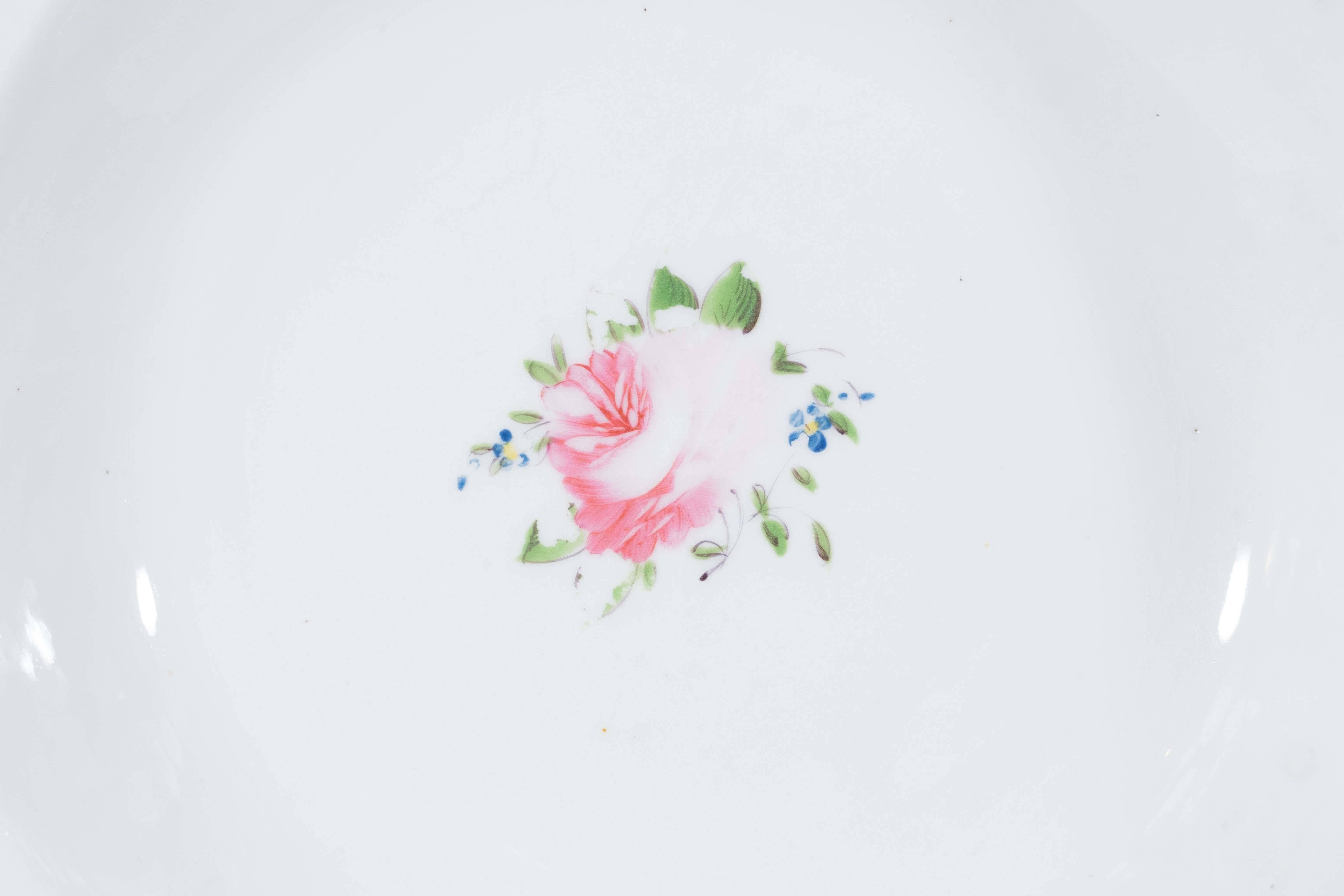 We are pleased to offer six large Staffordshire porcelain soup dishes decorated in a very feminine pattern with delicate pink roses, green leaves and small orange and blue flowers. The gadrooned edge is delineated by a gilded line. Altogether a