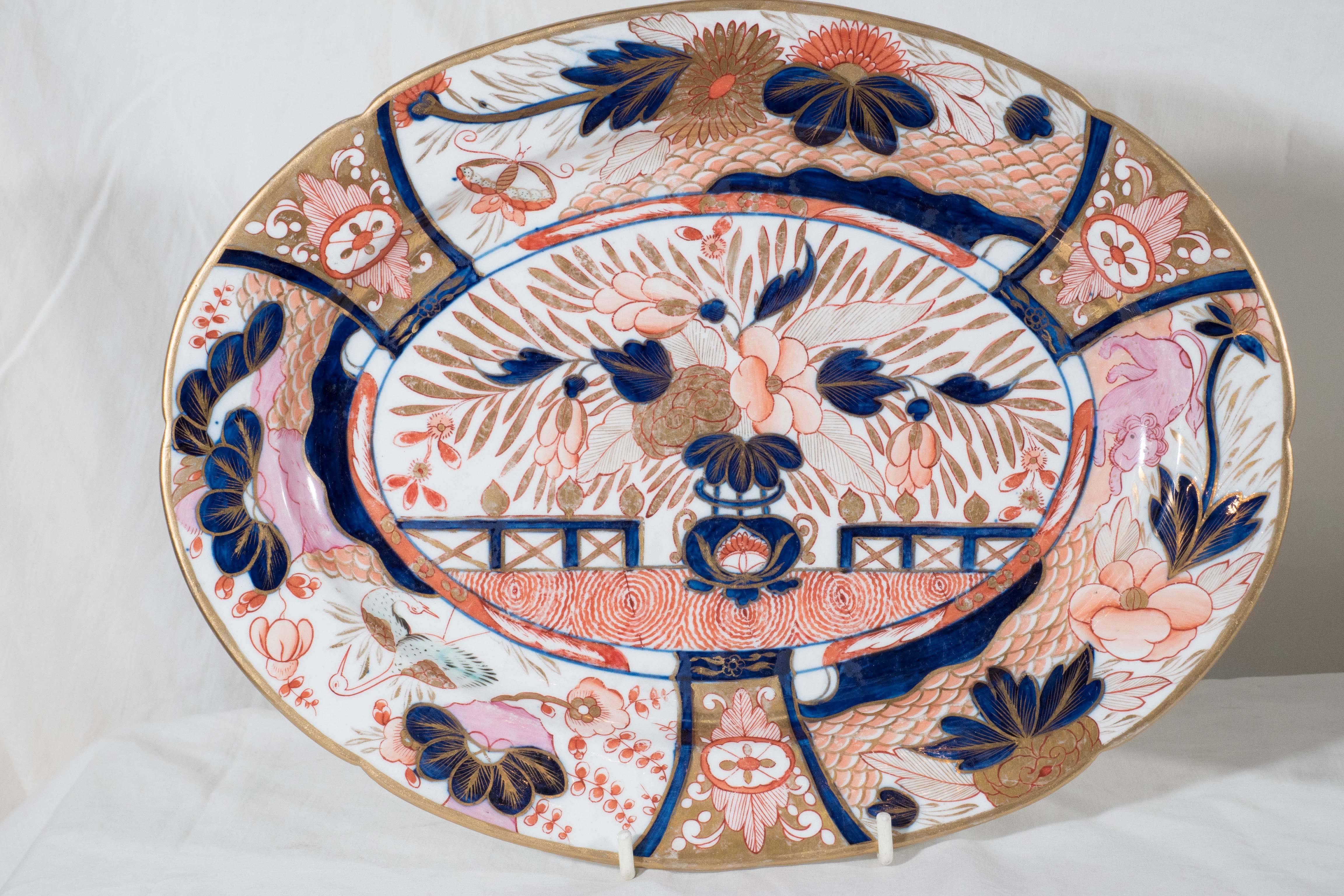 A pair of Coalport platters decorated with a traditional Imari scene. Hand-painted in cobalt blue, iron red and richly gilded these platters each have the whimsical pink lion and turquoise water birds which are the distinguishing characteristics of