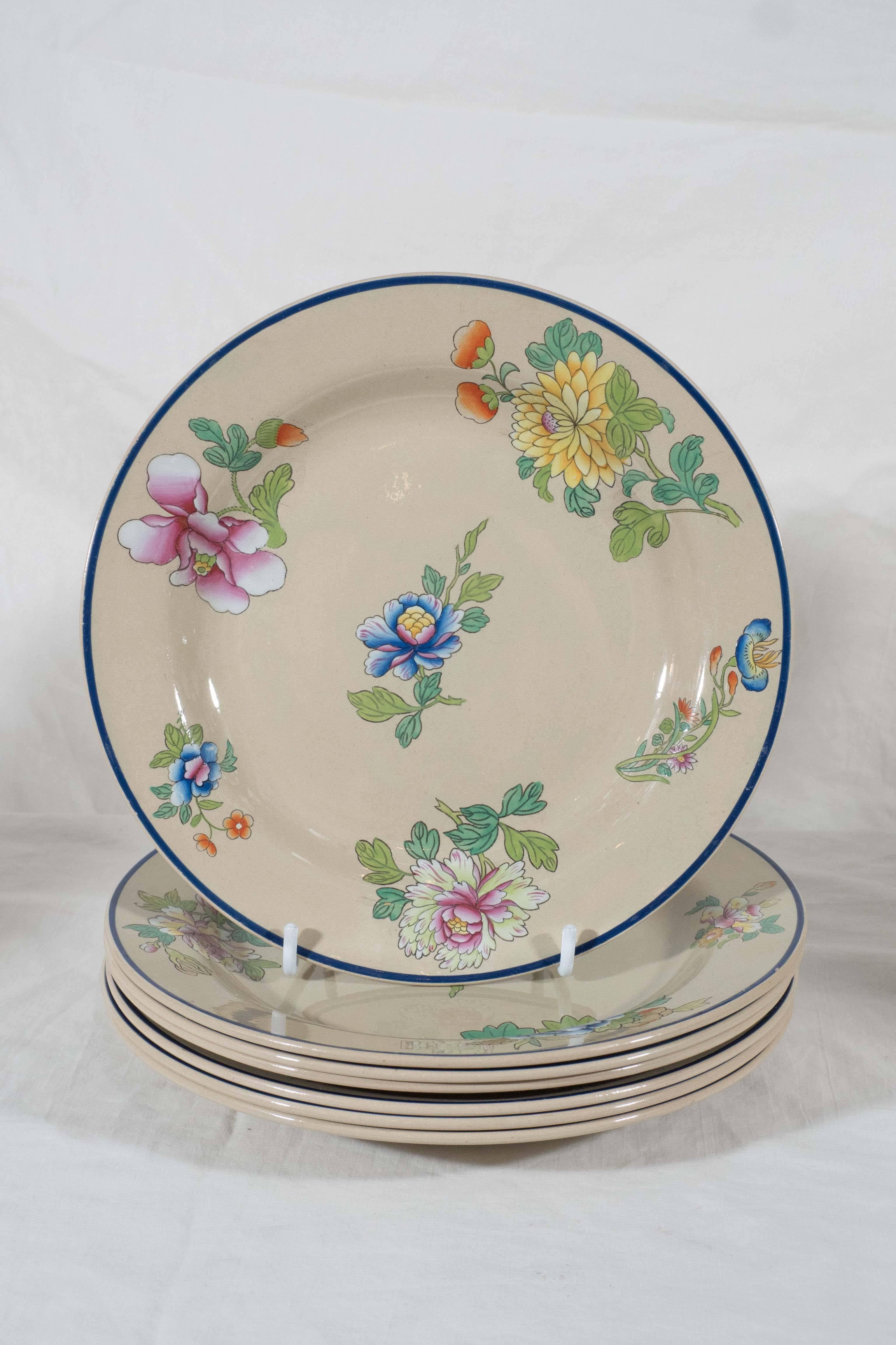 A Wedgwood Drabware part dessert service painted with flowers in soft pastel colors of pink, yellow and blue. The outer edge enhanced by a cobalt blue line.
The service consists of 10 dessert dishes, one rectangular serving dish and a pair of oval
