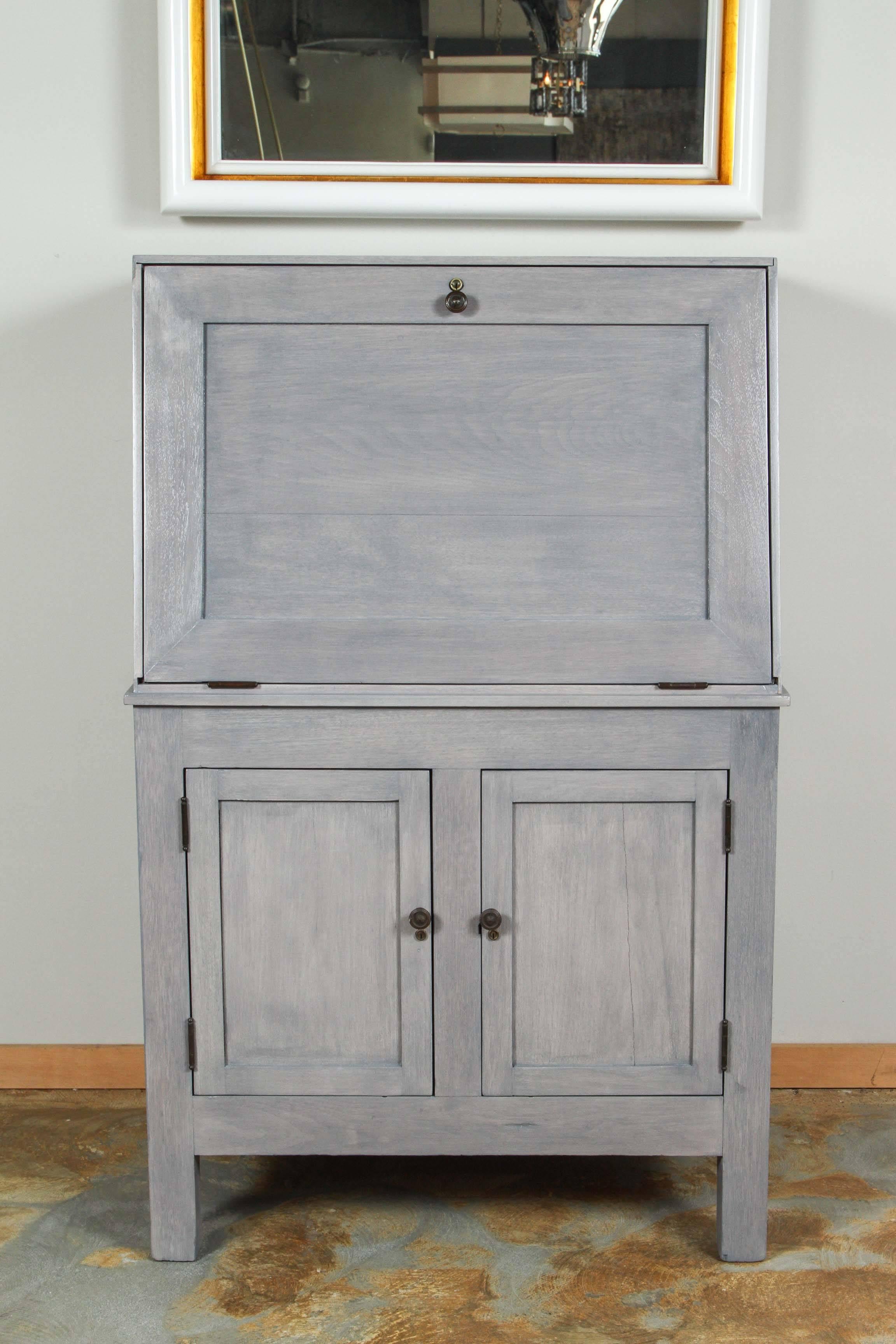 Vintage Arts and Crafts drop-front desk as been bleached and finished in a blue-gray stain. Original locks, but no key. New finish.Minor splits and separation in wood, including front door and sides, have been repaired but we cannot guarantee would