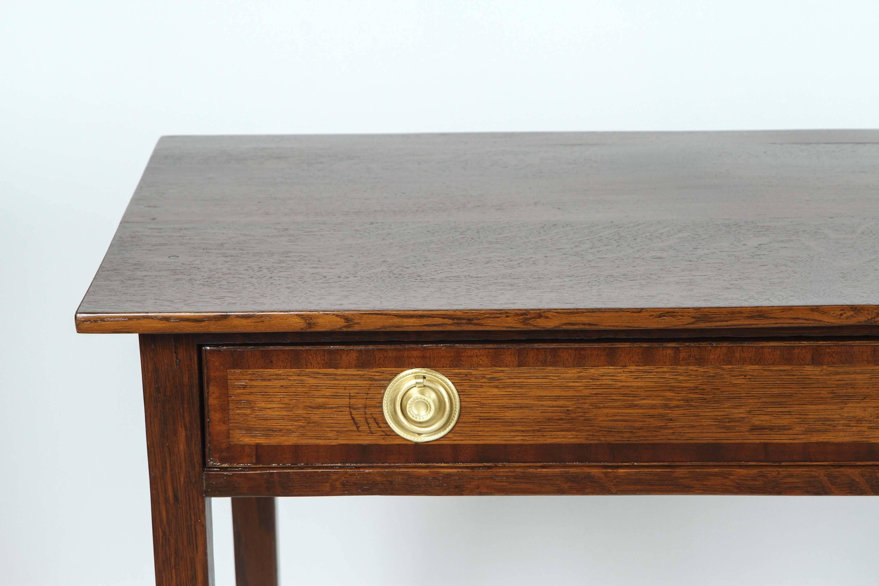 Antique Georgian oak console table newly refinished with newly polished original brass pulls and raised on square tapered legs, circa 1870.