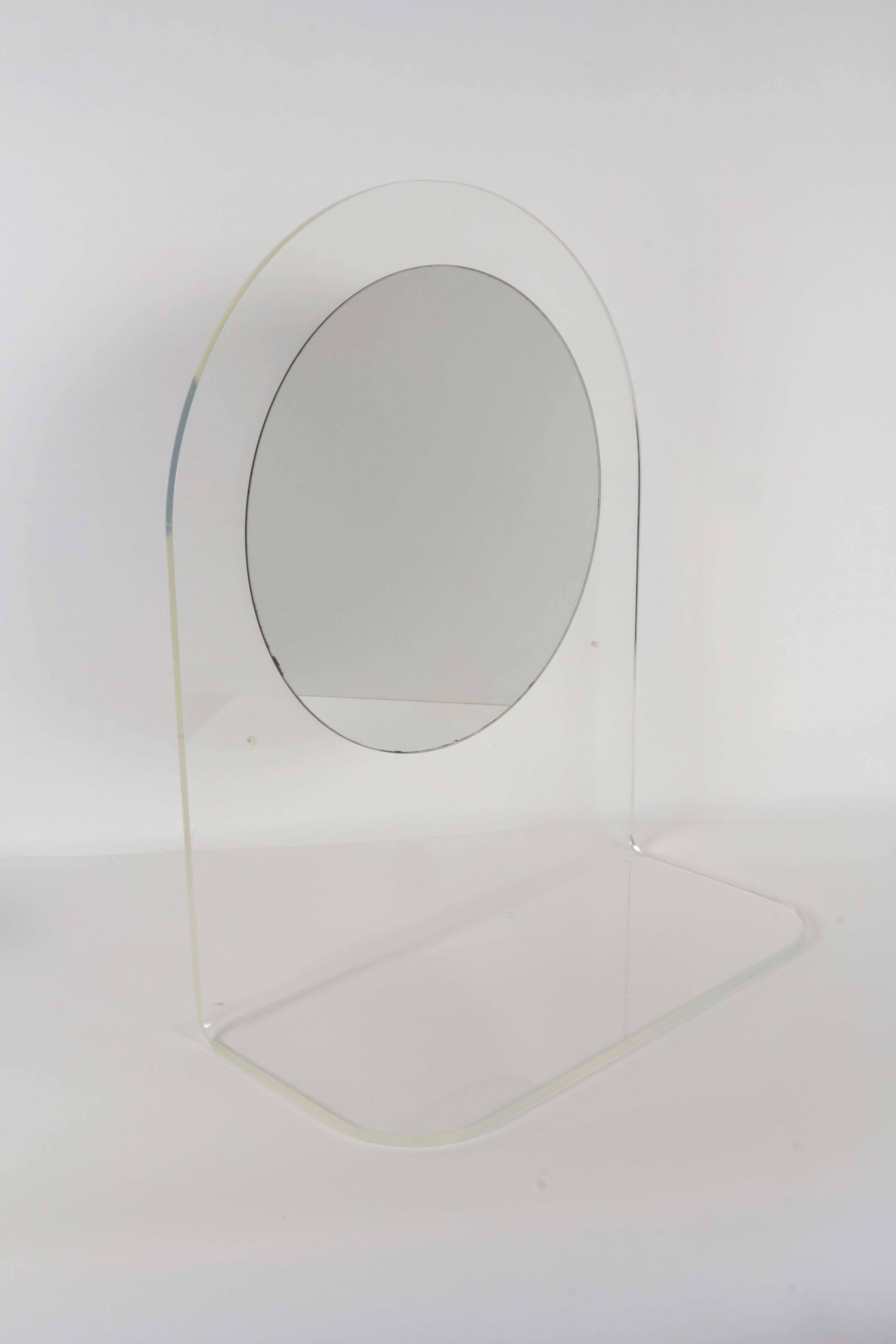 A highly modern wall shelf, with mirror affixed to an arched Lucite back; includes holes to mount on wall. Very good condition, wear consistent with age and use.

10425