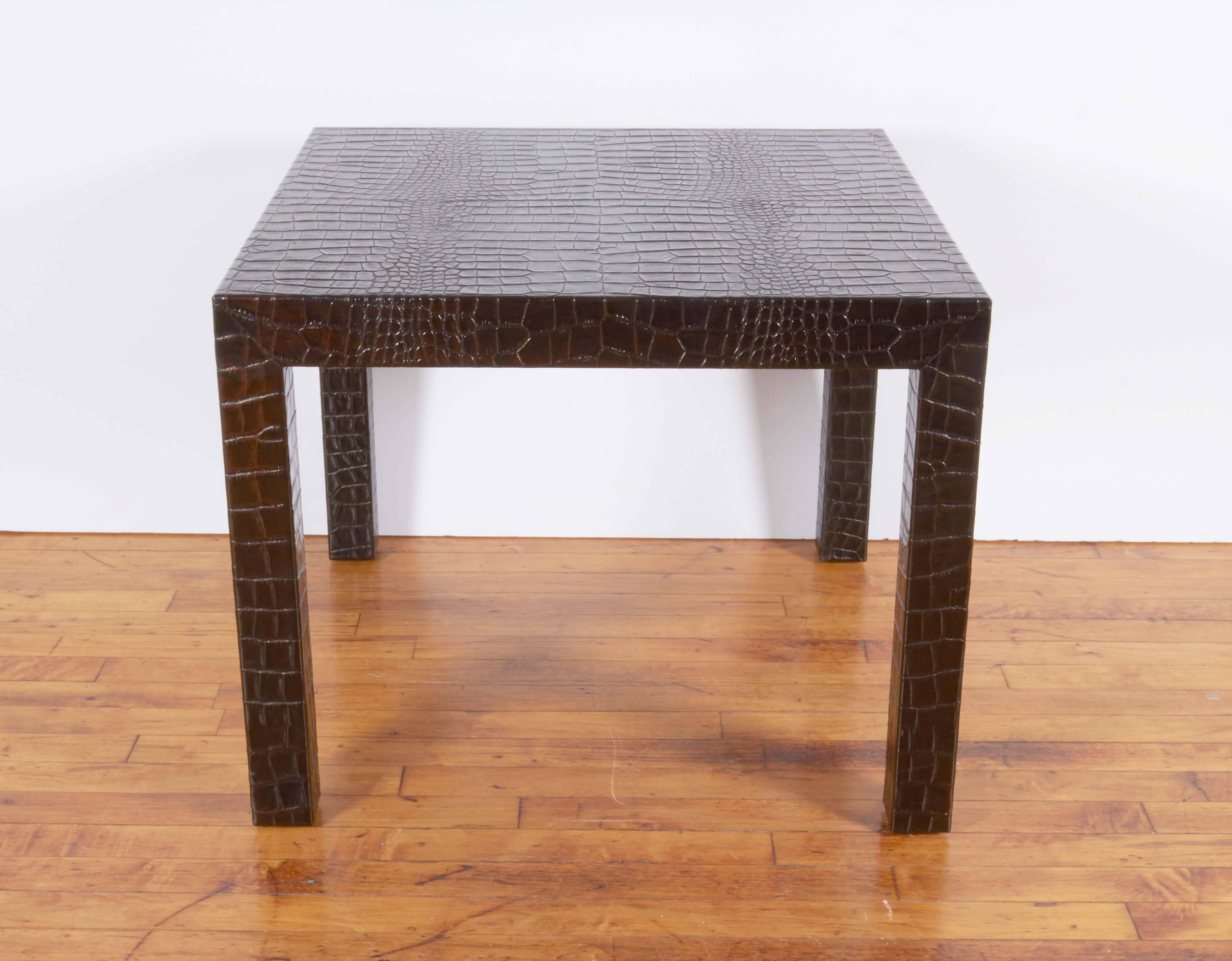 A pair of side and end Parsons tables, inspired by designer Karl Springer, covered in dark brown leather, embossed with alligator skin pattern, against wood bases. The tables remain in very good overall condition, with minor presence of wear and