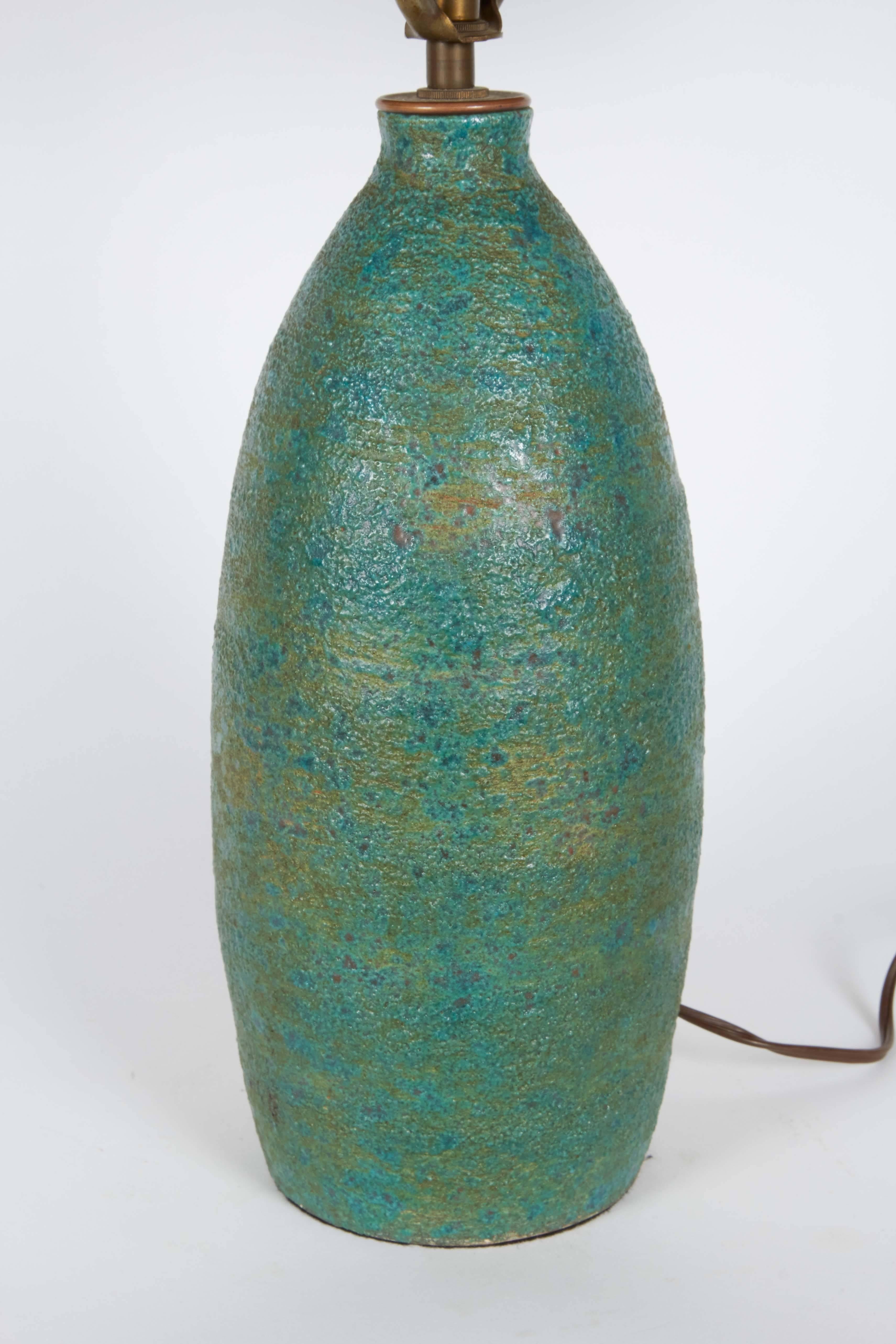 A pottery lamp with single socket on rounded body with teal lava glaze, circa 1960s. Wiring and socket to US standard. This lamp remains in very good vintage condition, wear consistent with age and use.