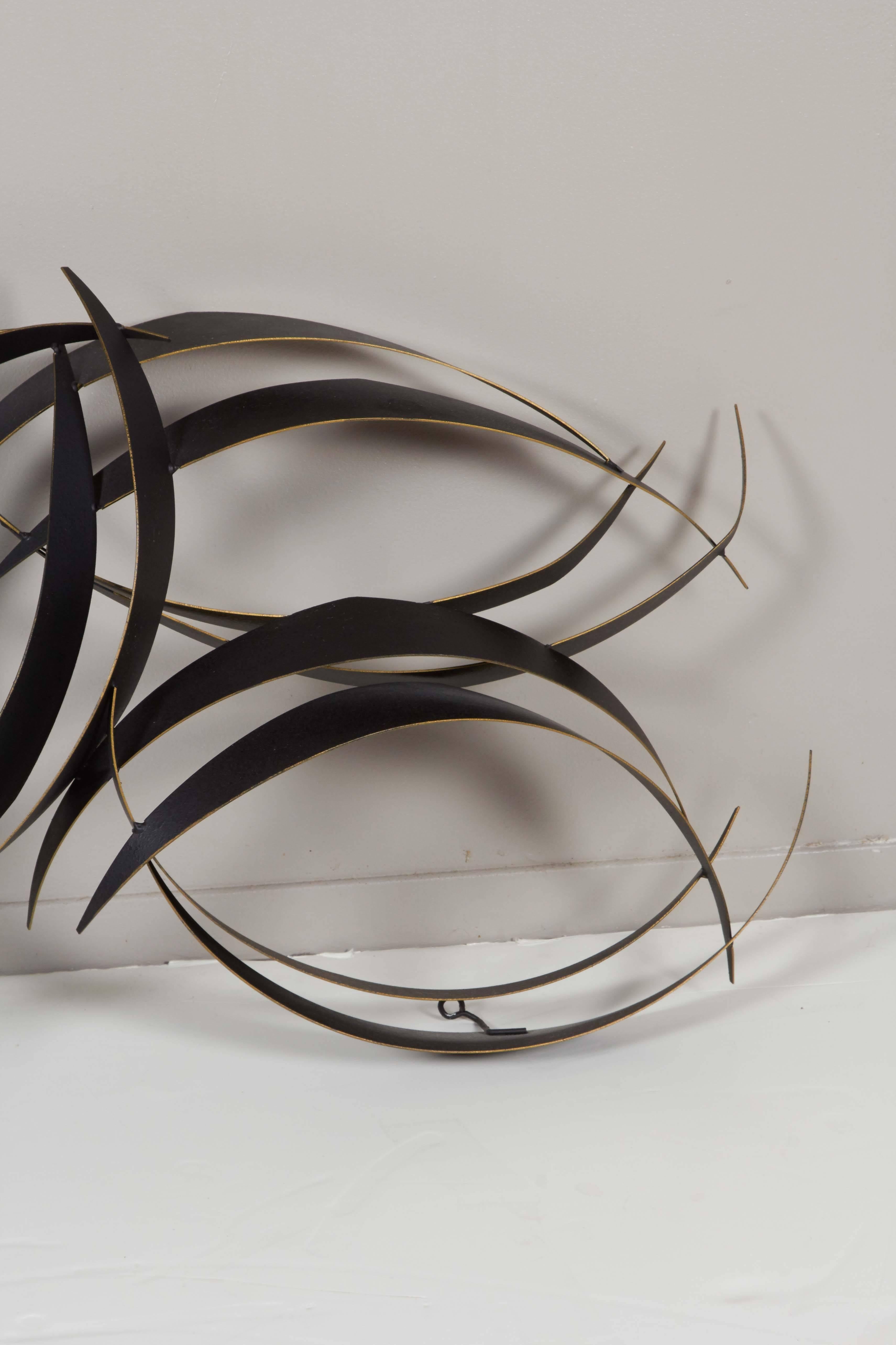 A hanging wall sculpture by Curtis Jere, comprised of sheets of curved metal, with gold to the edges. Signed [© C. Jere 1997]. Very good condition, consistent with age and use.