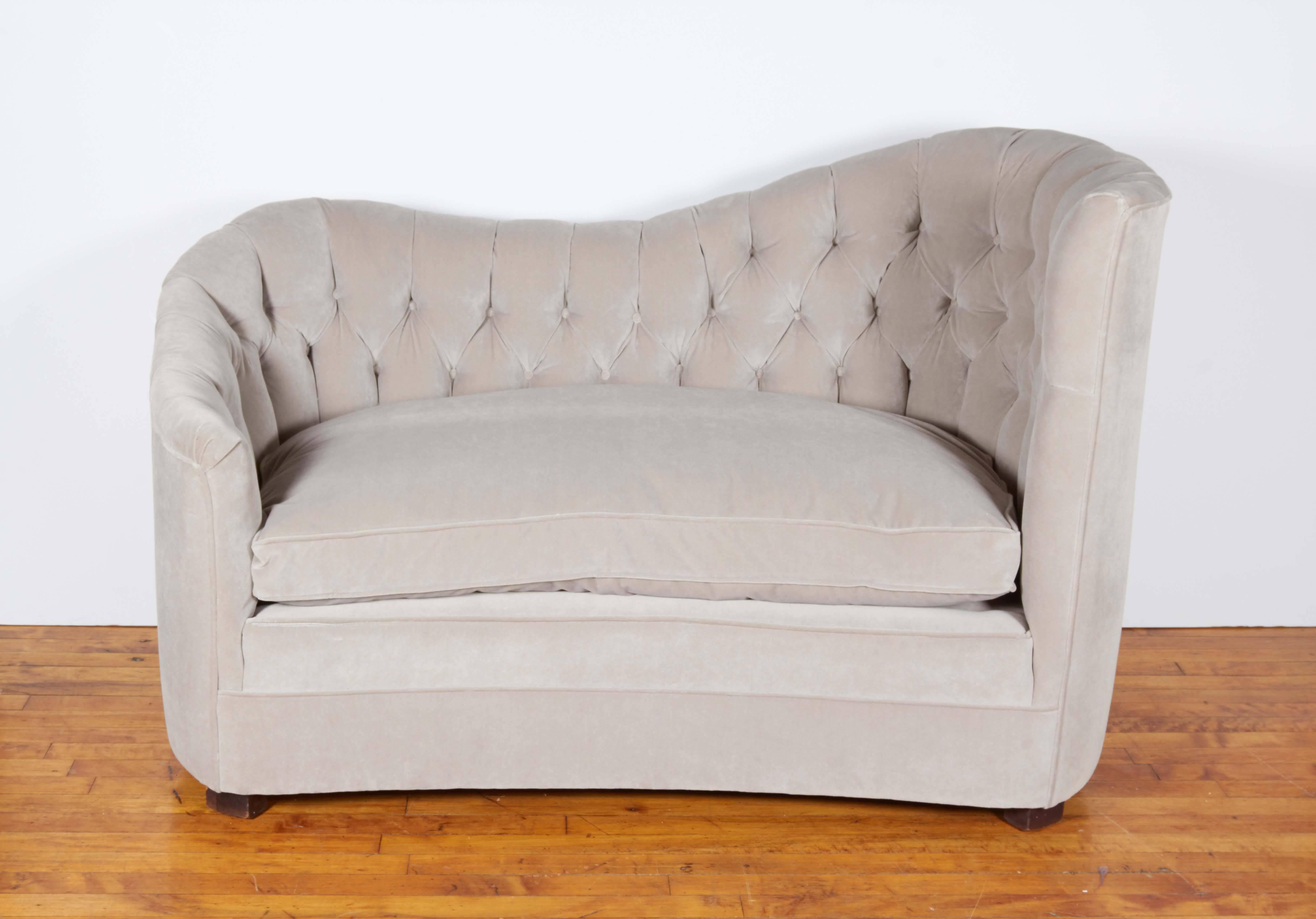 A glamorous pair of French Art Deco settees, manufactured, circa 1930s, each entirely upholstered in gray velvet, with curvaceous tufted backs and down cushions. Excellent vintage condition, newly reupholstered.
