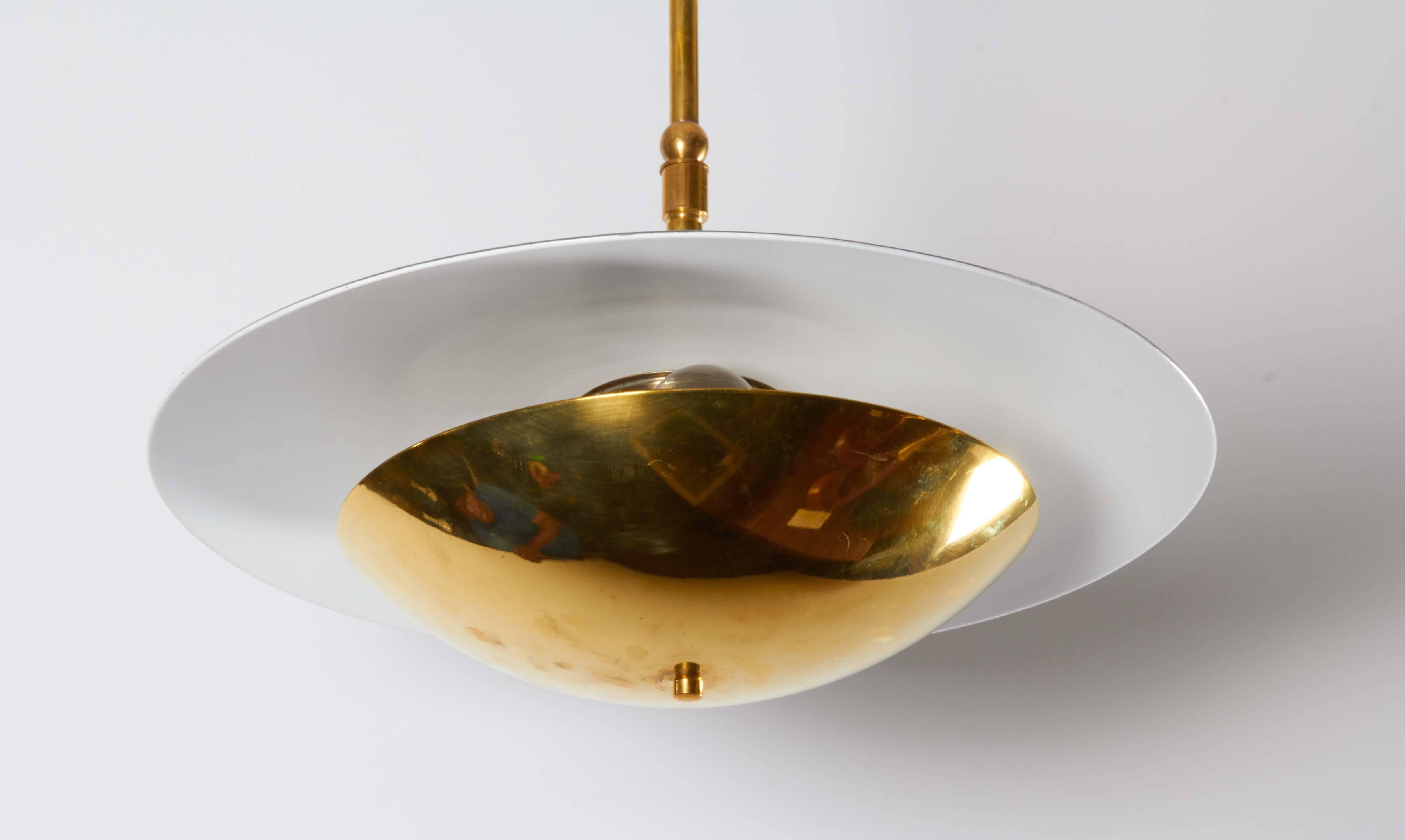 A rare Italian modernist reflector pendant, produced circa 1950s and attributed to Stilnovo, the fixture in brass and gray and white enameled aluminum, suspended from an adjustable rod. Wiring and sockets to US standard. Good original condition,