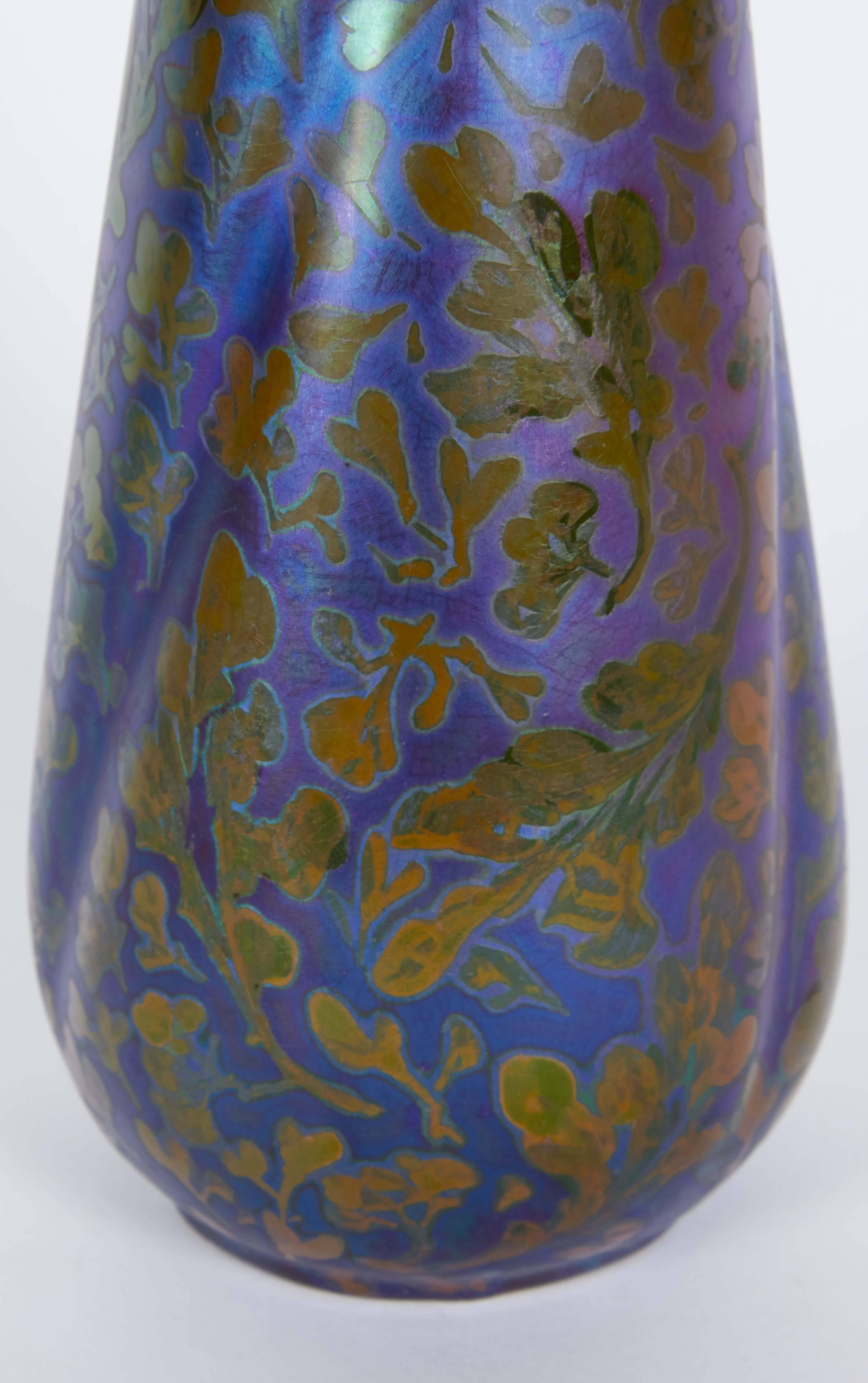 A striking Art Nouveau pottery vase by French ceramicist Jacques Sicard for Weller Pottery, depicting scrolling foliage, with iridescent luster glaze. Markings include signature [Sicard] to the base, underside numbered. This piece remains in very