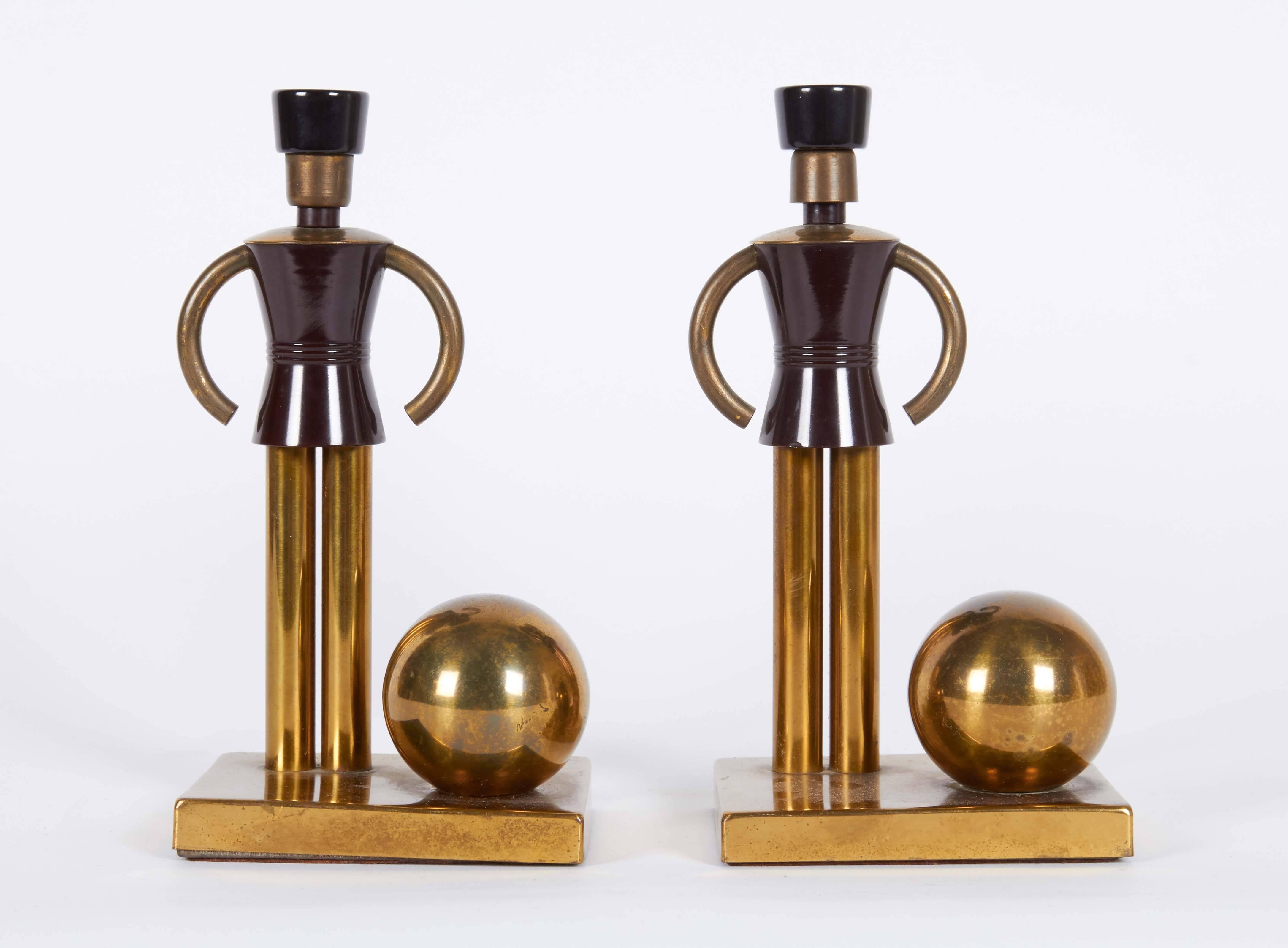 These streamlined Art Deco brass bookends, produced, circa 1940s, designed by Walter Von Nessen, depict figures of soldiers, detailed in black bakelite, with ball motif. Very good vintage condition, wear consistent with age and use.
