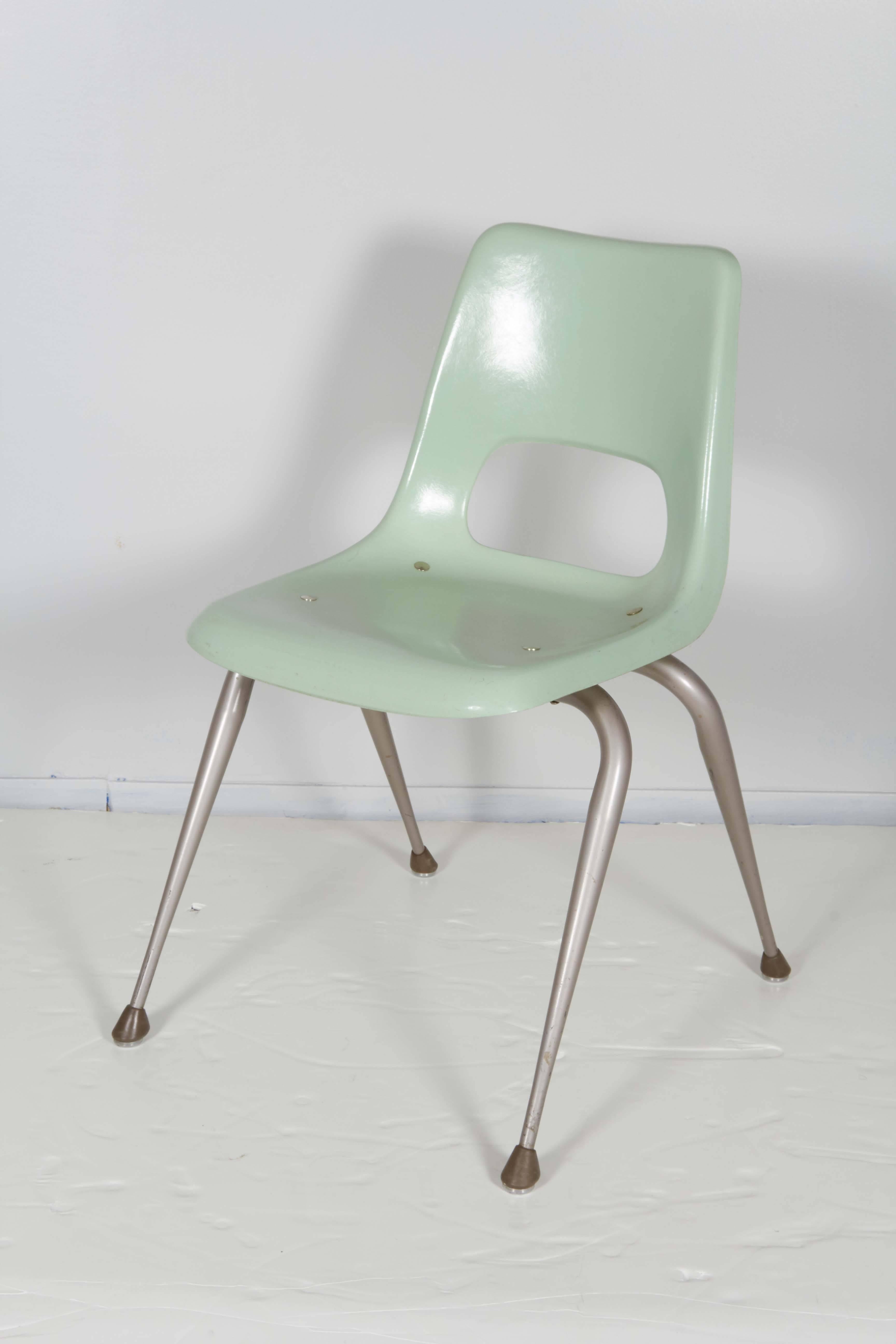 A vintage set of eight chairs by Brunswick, each in mint green molded fiberglass on metal legs. Includes maker's mark [B/Brunswick] indicating manufacturer. The chairs remain in good vintage condition, with age appropriate wear.