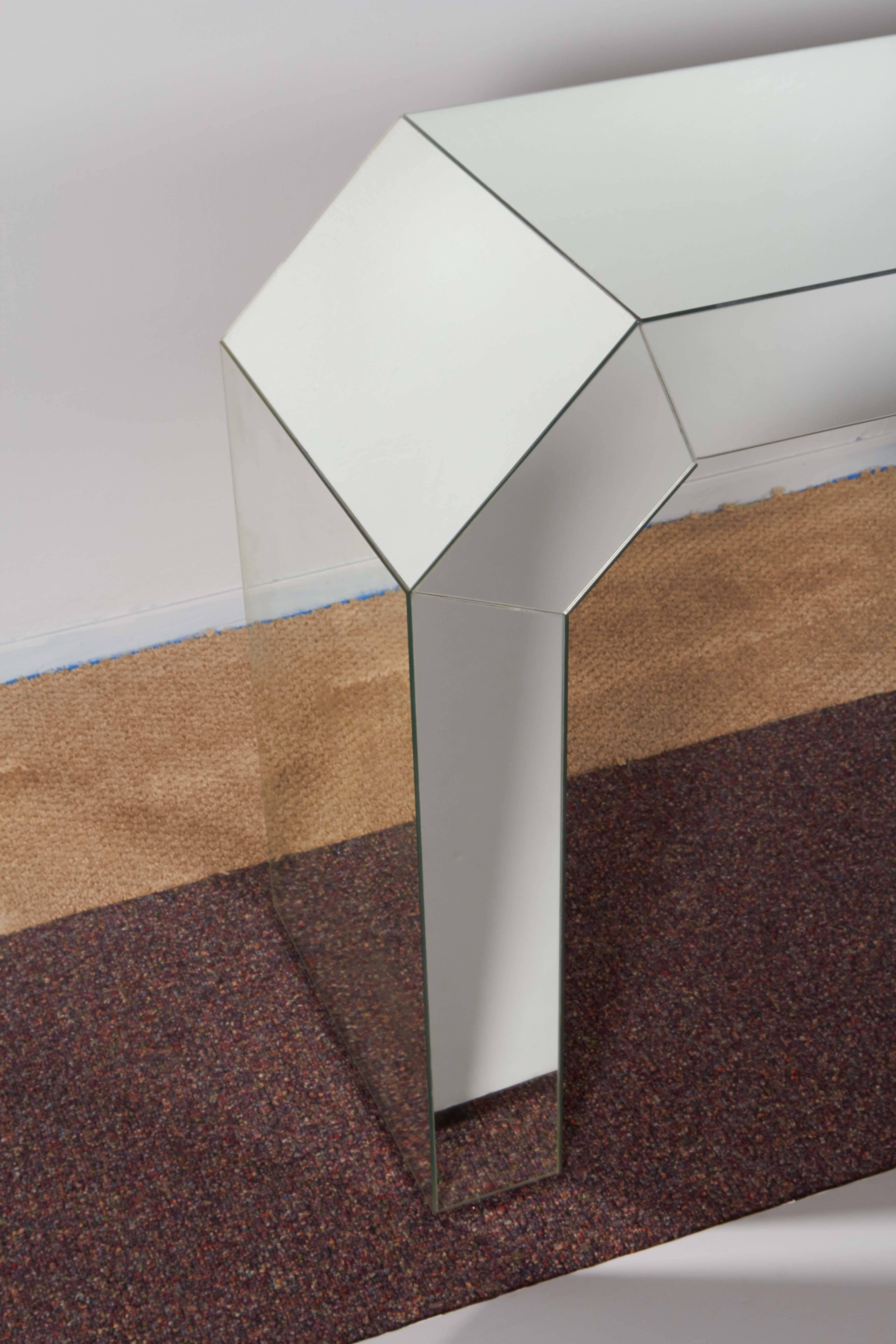 A modern geometric style mirrored console table, in Minimalist waterfall form with faceted corners. The console is in very good condition, consistent with age and use.