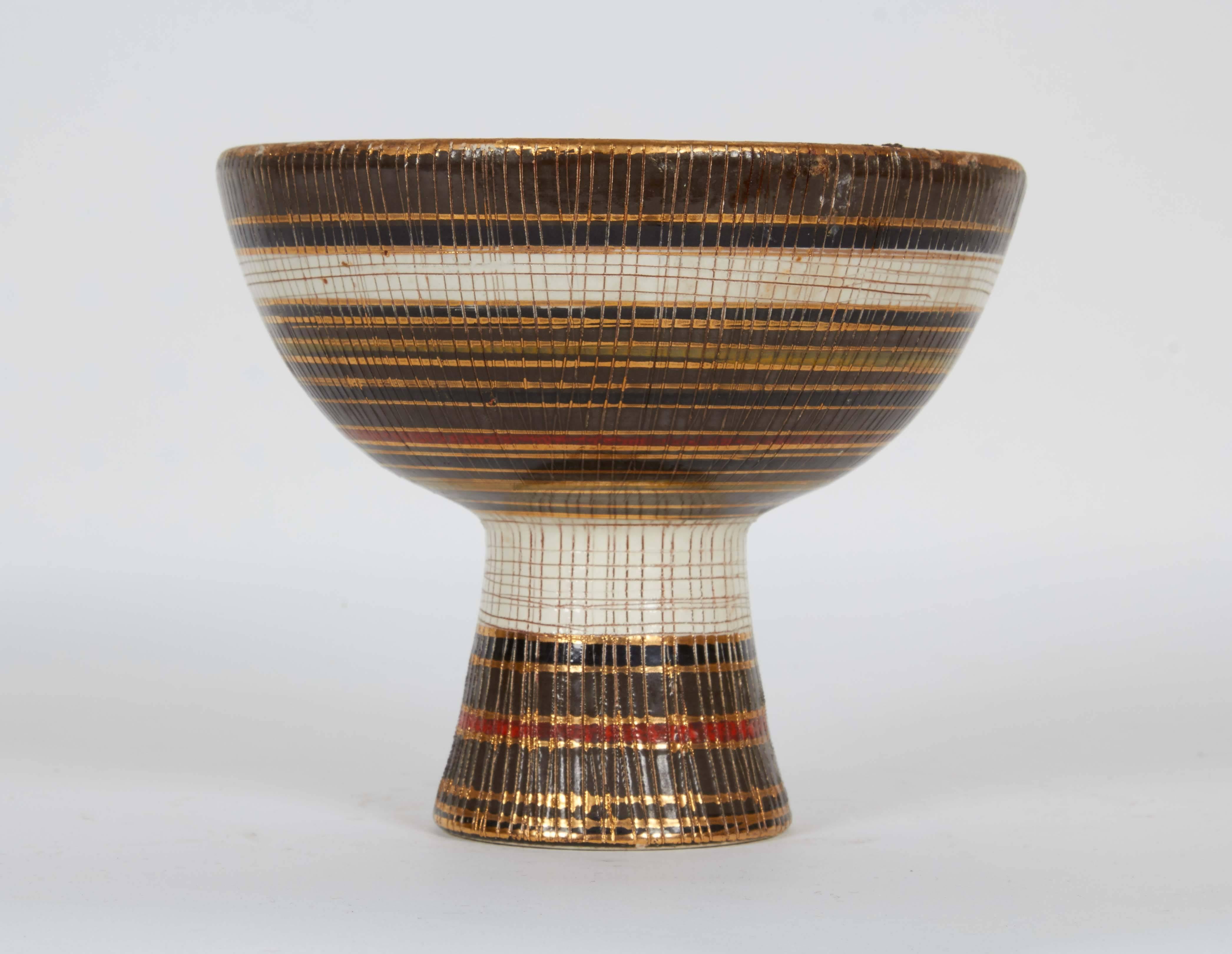 An Italian Sgraffito ceramic footed bowl or planter, produced circa 1960s by Bitossi from the 'Seta' series, the glaze, in horizontal bands of browns, black, white and red, accented with gilding and decorated with criss-cross incising. Signed to