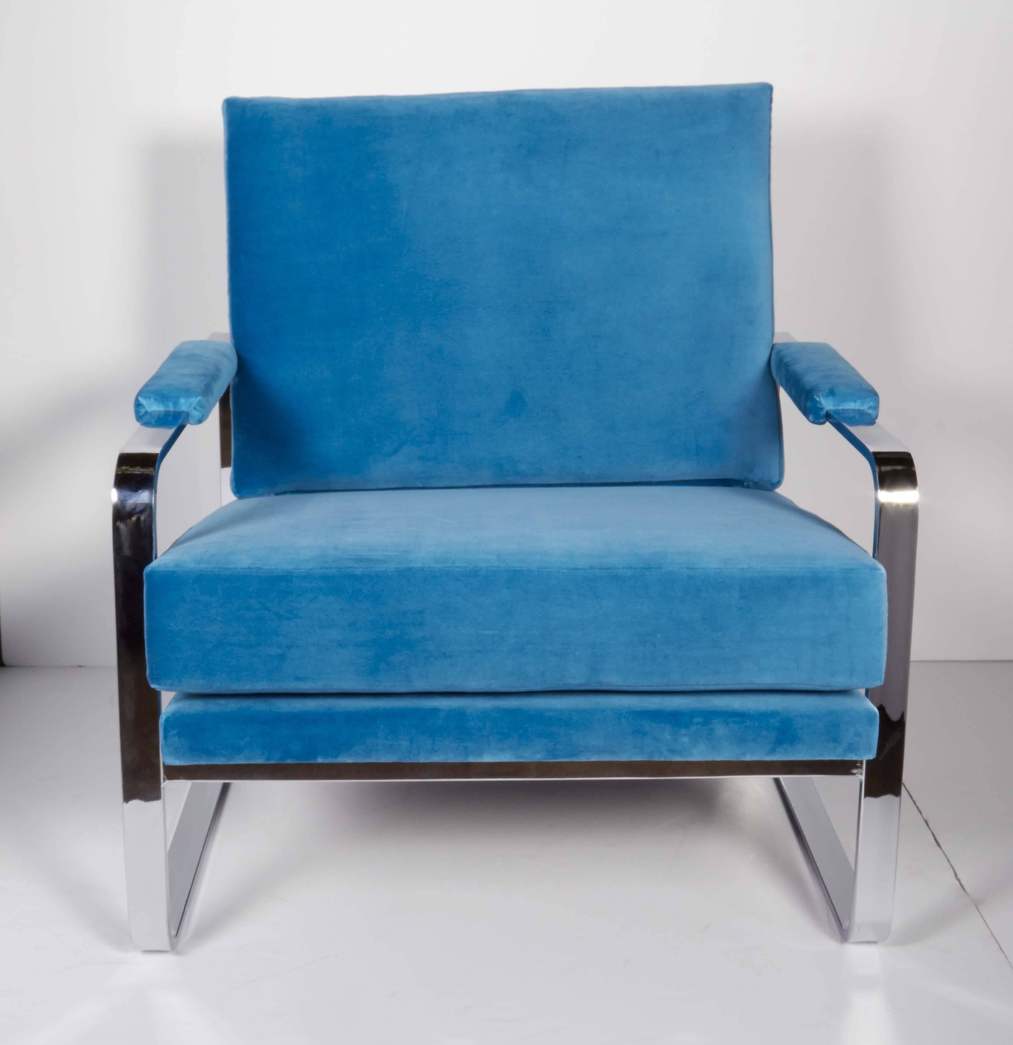Superb Mid-Century Modern lounge chairs with gorgeous profiles. The chairs feature steel frames with cantilevered forms and polished chrome finish. Cushions have been refitted and reupholstered in a dramatic cerulean blue velvet. Beautiful from all