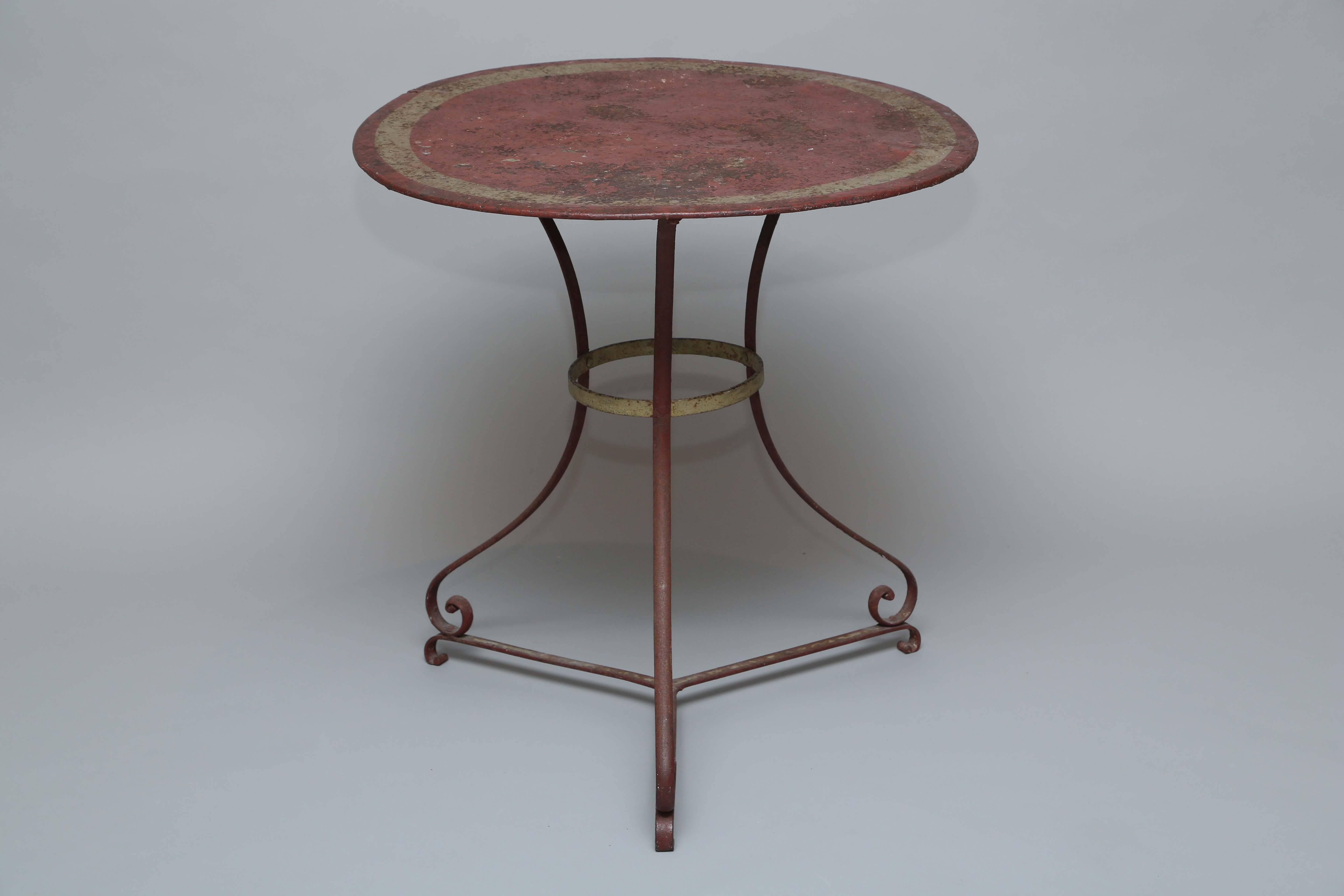 Cafe table of iron, with its original painted and parcel-gilt finish, having a round top on gueridon base of three curved legs, ending in scroll feet and joined by a ring central stretcher.

Stock ID: D9367