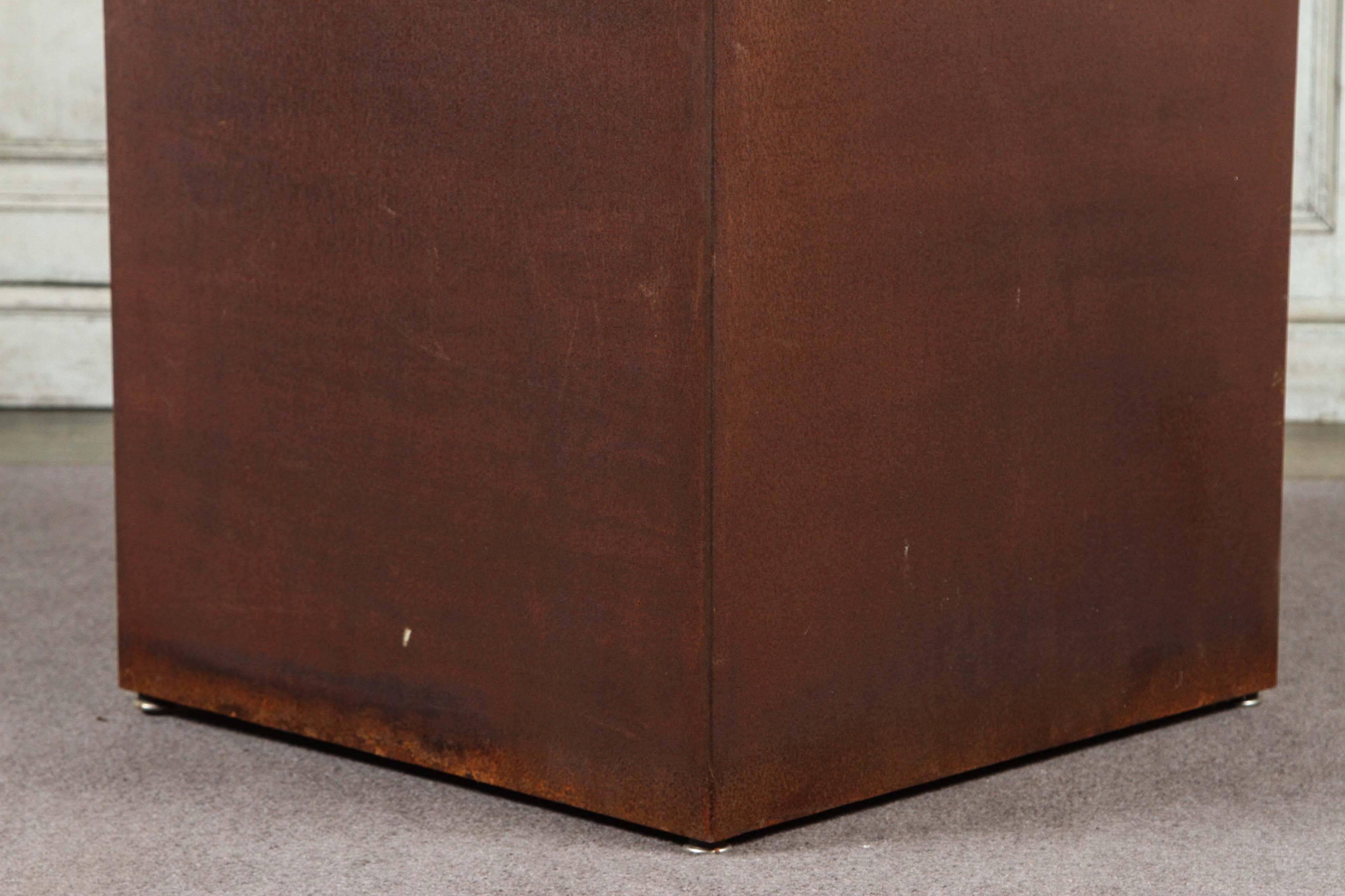 Socle ou piédestal carré en métal patiné par Lee Stanton. De forme moderne et minimaliste, ces supports ont un aspect à la fois chaleureux et industriel.  Disponible en trois hauteurs : 20 pouces, 26 pouces et 32 pouces. D'autres finitions sont