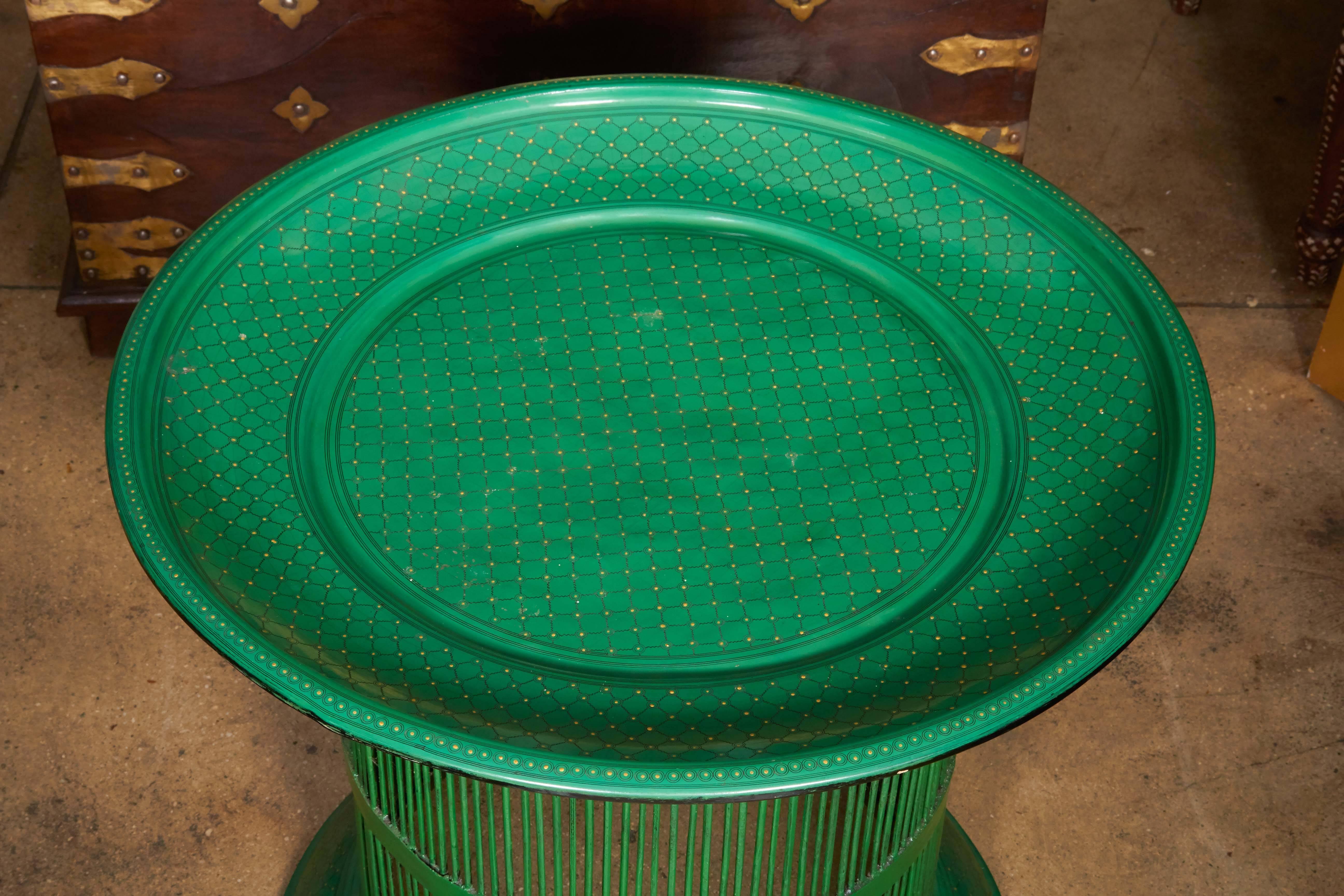 A round bamboo drum table from Myanmar in green lacquer and trimmed in a fine pattern in gold paint. A broad top over a thin ribbed base.
