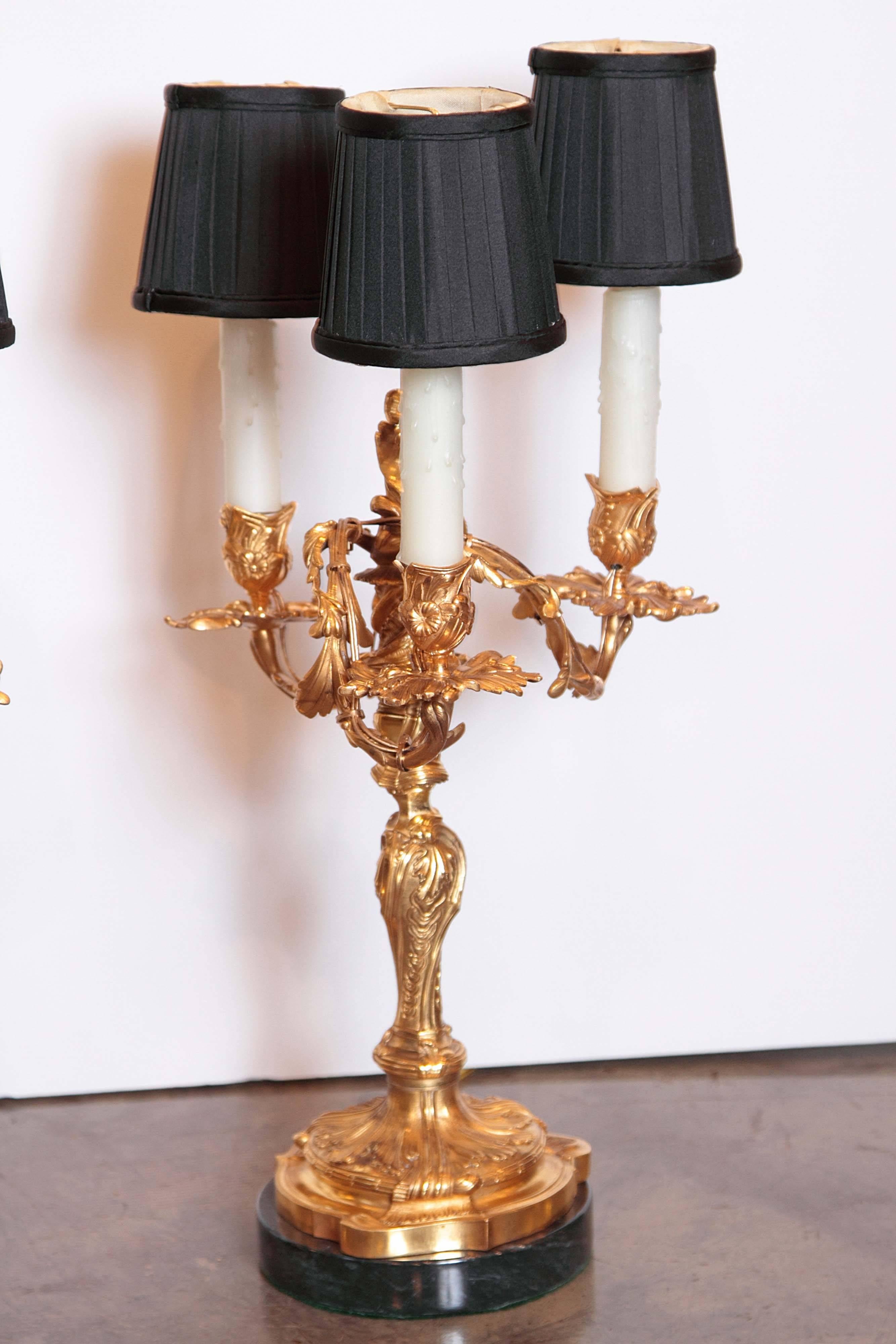 Pair of 19th century French Louis XV gilt bronze three-light candelabra lamps on marble bases signed in script on the base Henry Dasson, 1882.