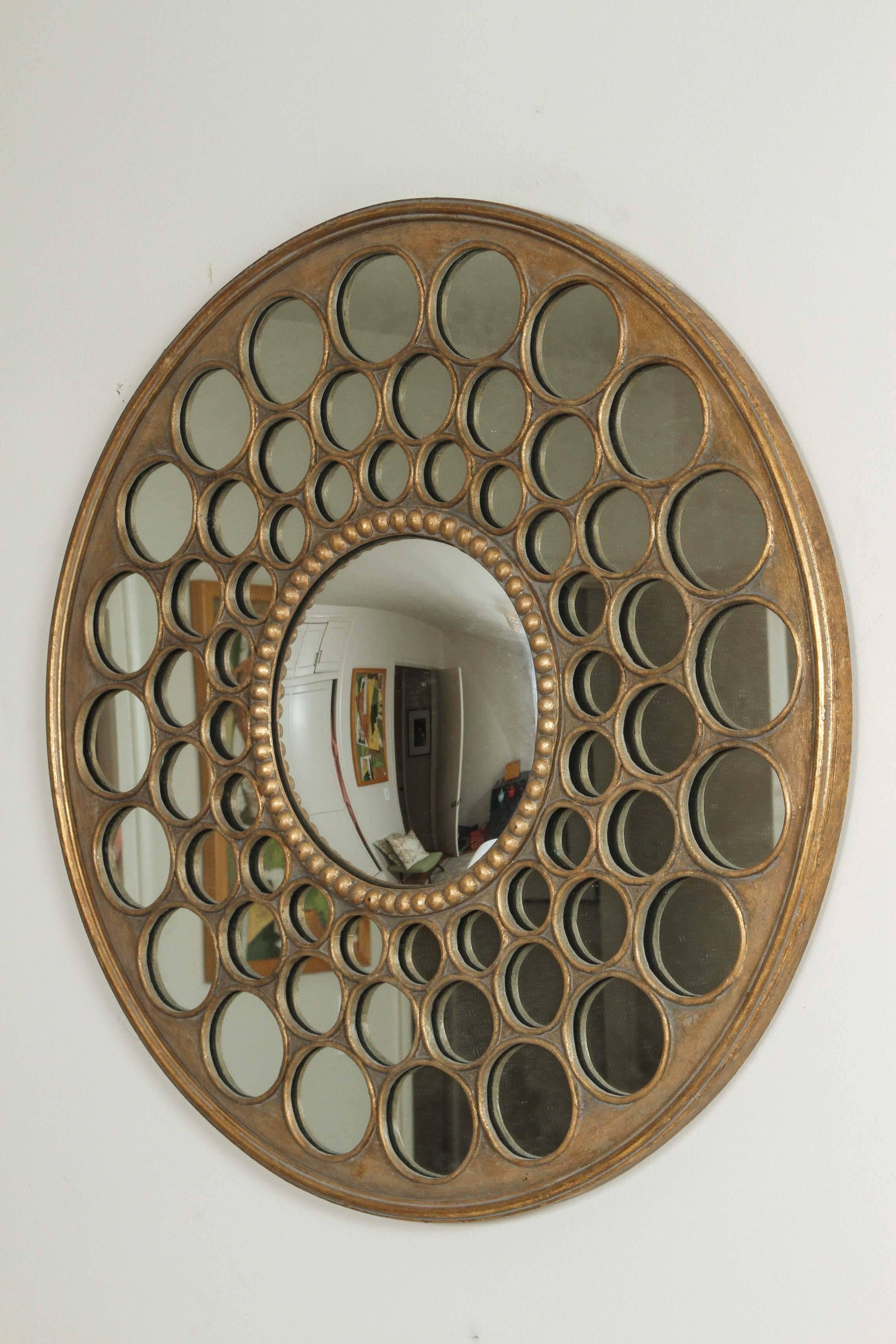 With a convex center and surrounding circles blossoming from it, this mirror is a great statement piece to complete any blank wall. The gold leaf finish makes the mirror an elegant and timeless piece.