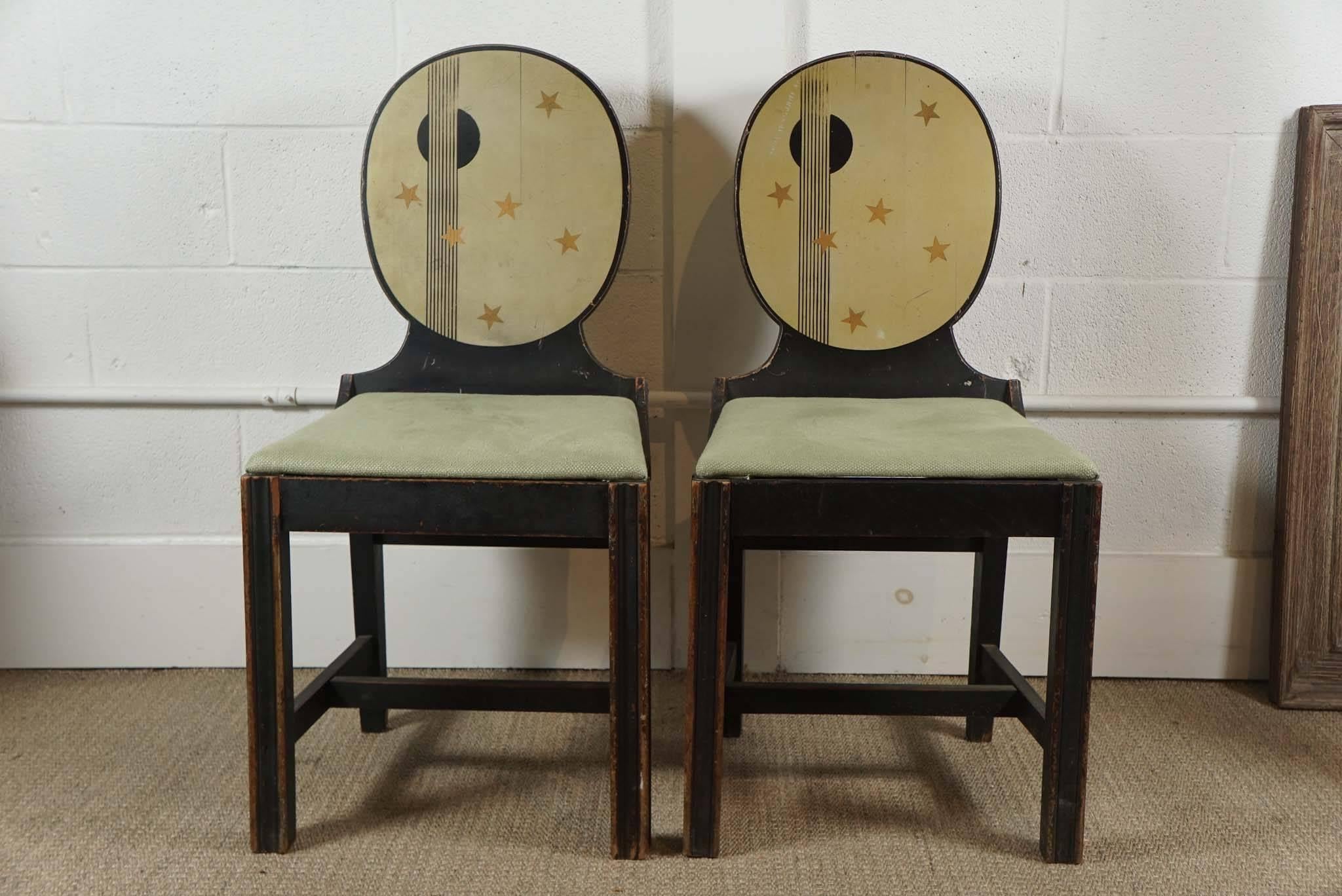 Here are two painted wooden chairs with oval backs. The chairs have a whimsical decorative detail with a star motif on front and back.