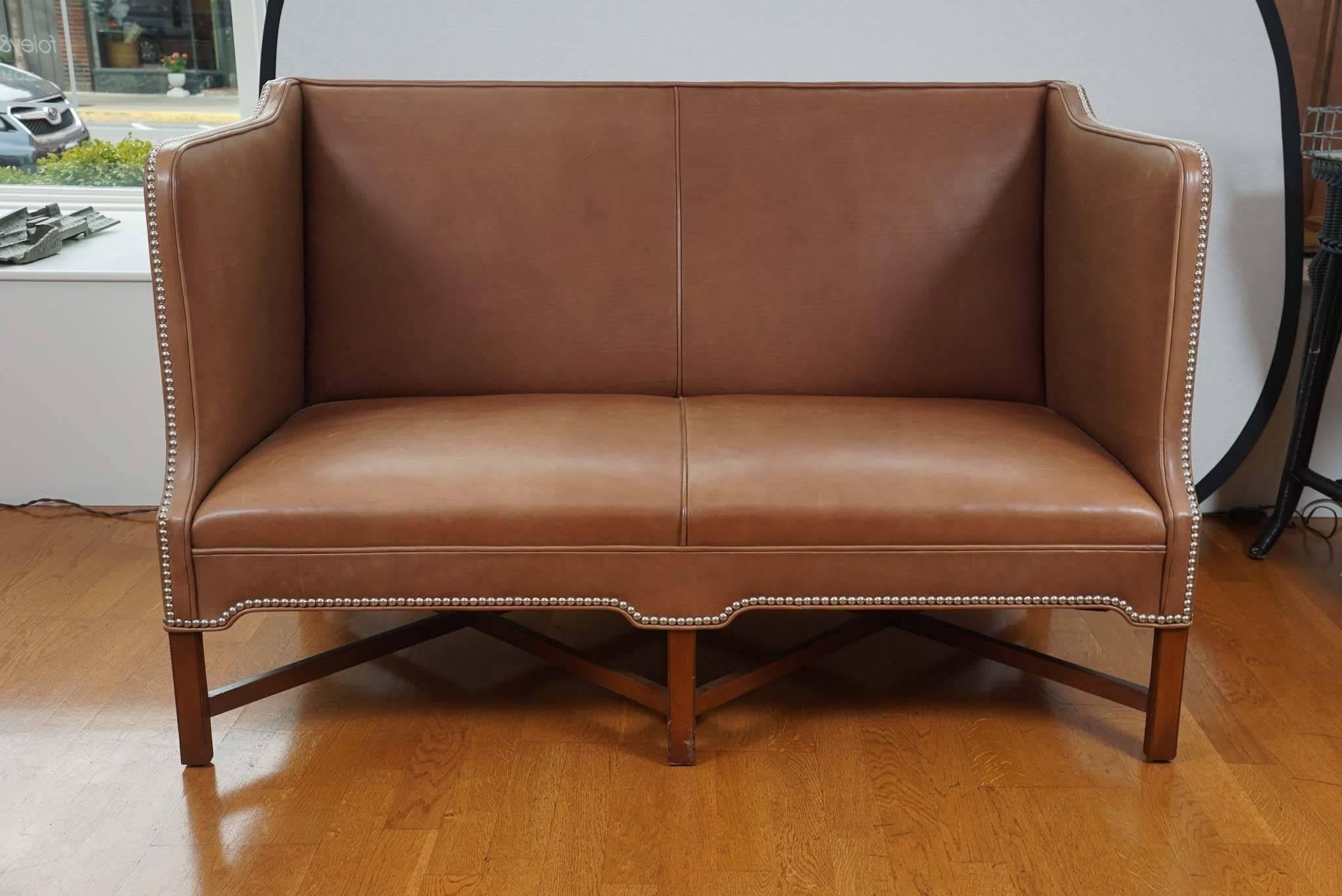 Handsome, Danish leather sofa, on a stained, beechwood frame,
with silver tack detailing. Designed by Kaare Klint for rud.