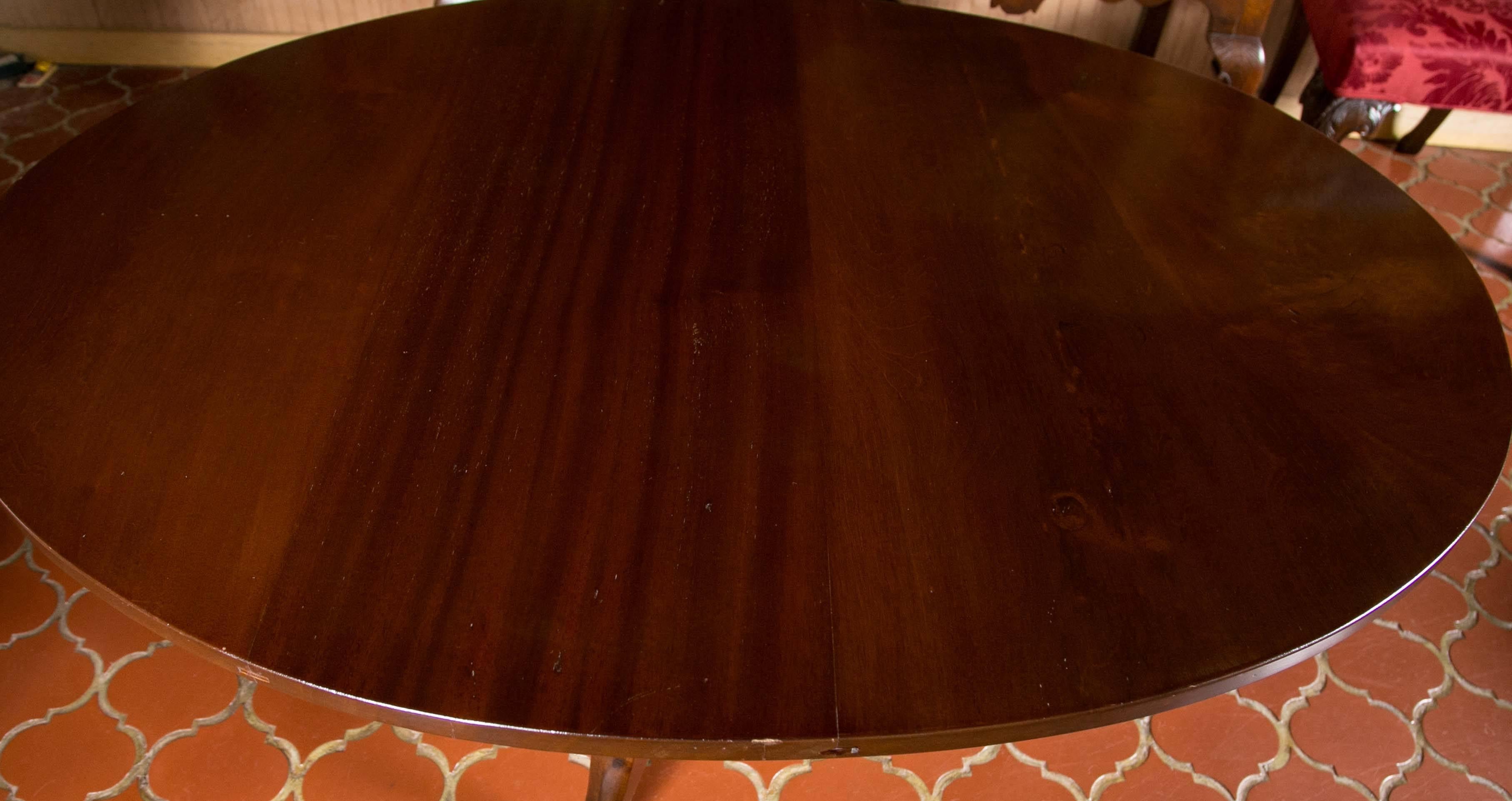 Unusual oval shape tilt-top table. Solid mahogany top with sturdy tripod base. Seats four to six. Perfect for those rooms demanding unique solutions.