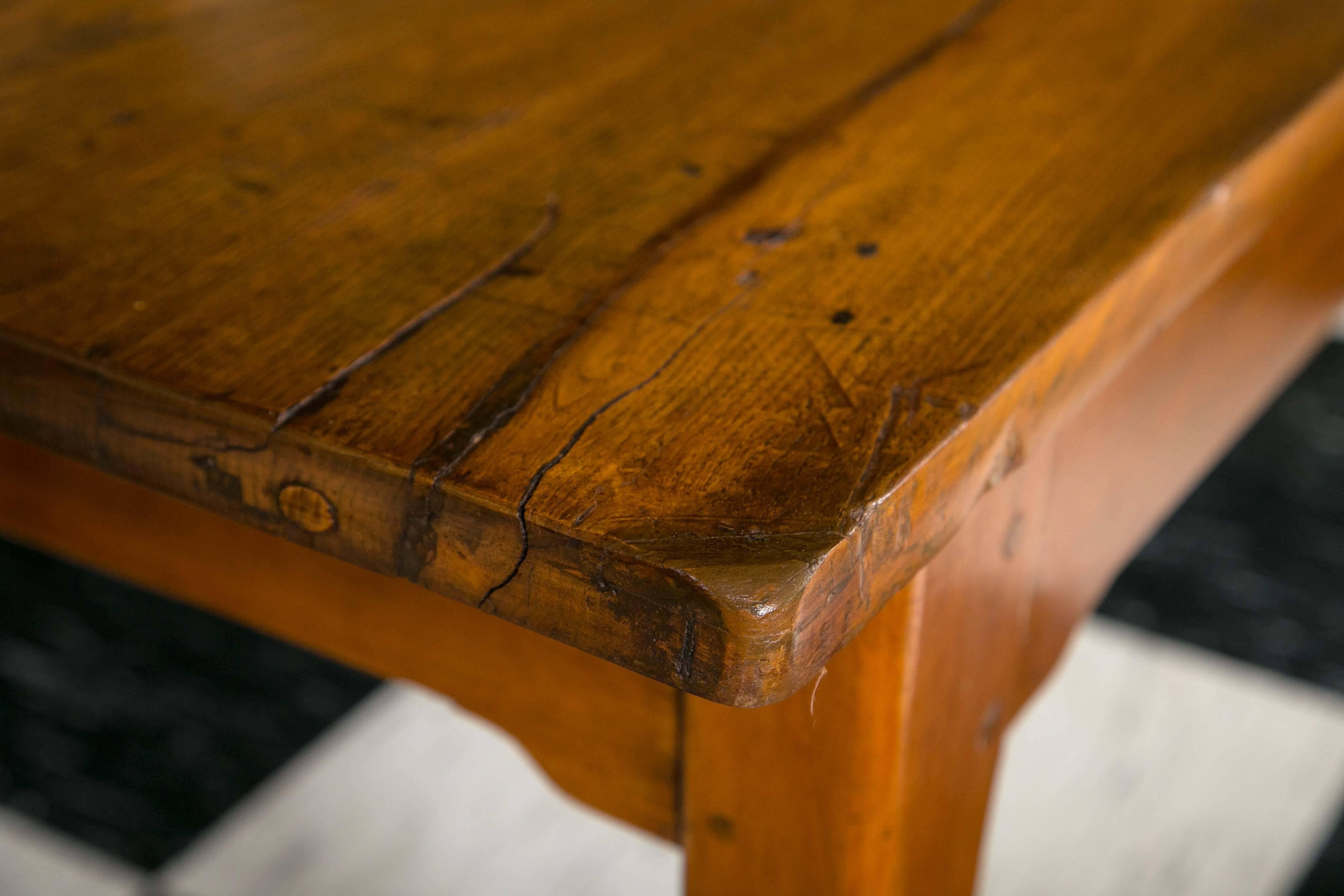 Traditional French elm farm table with sturdy tapered legs. Solidly constructed with thick top and traditional wood pegs. Wonderful warm patina and aged top.