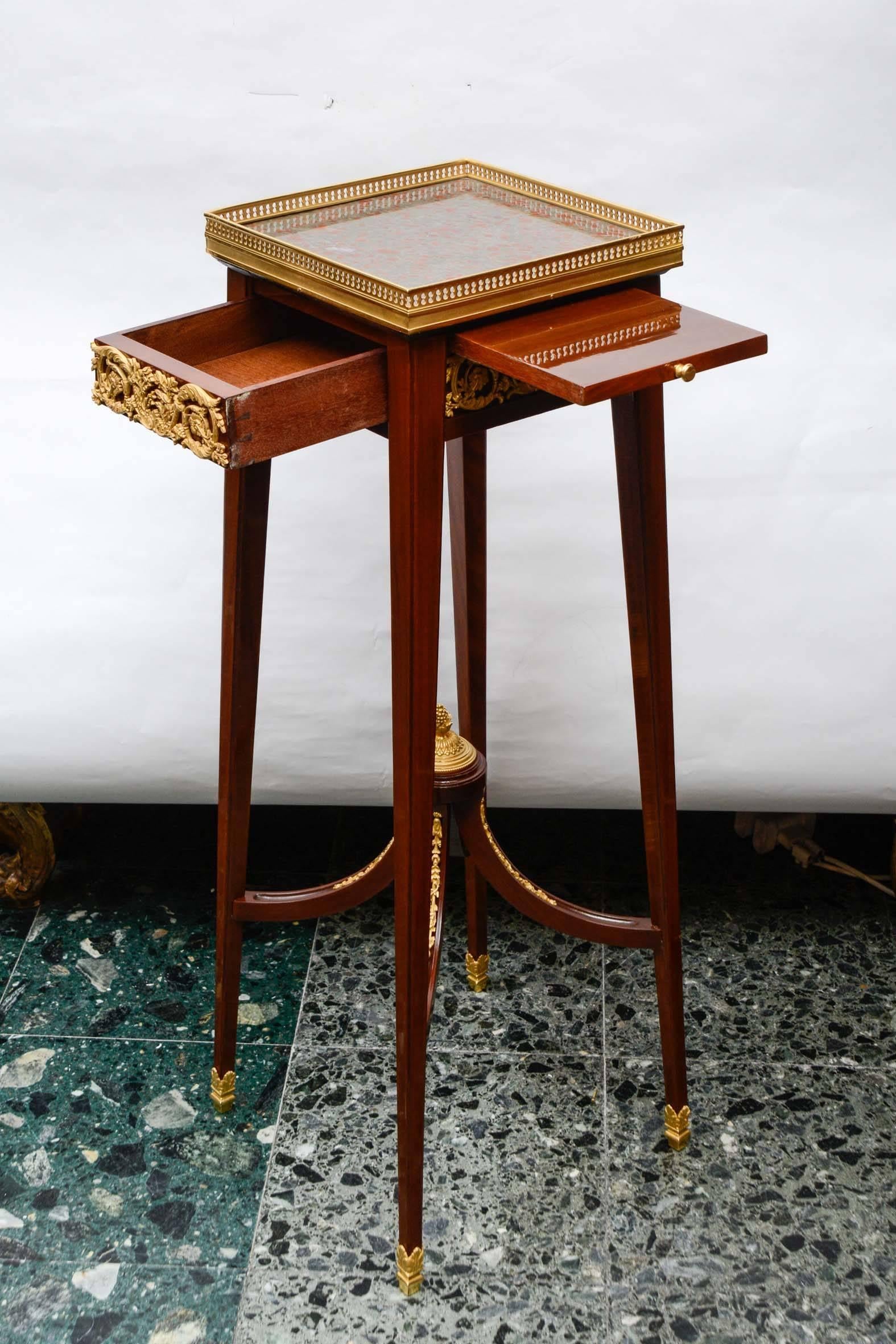 Rare table, in mahogany decorated with gilded bronze. The top is in marble.
It has a secret system for the drawer.

