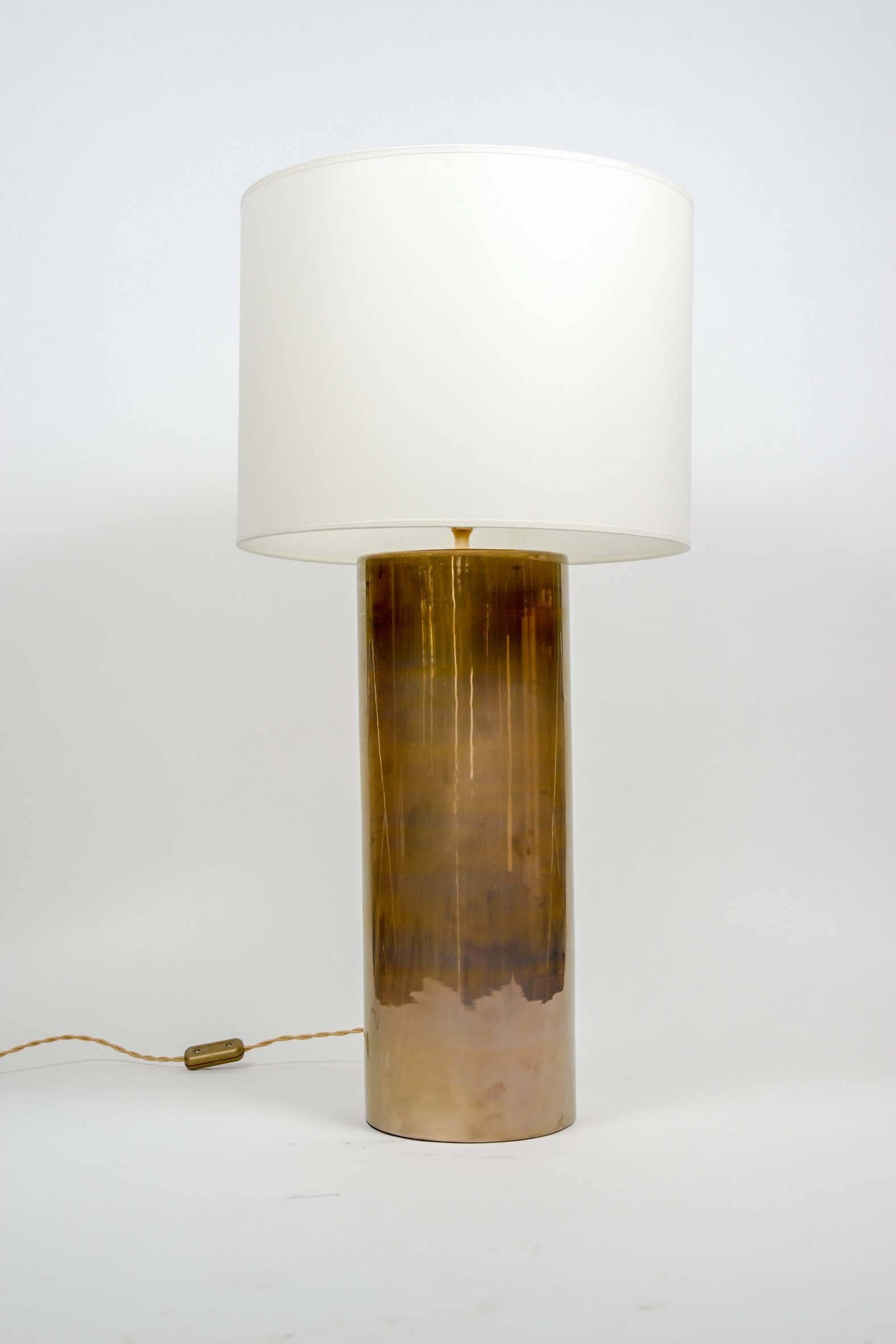 Elegant and simple pair of lamps, made of a brass cylinder with round edges.