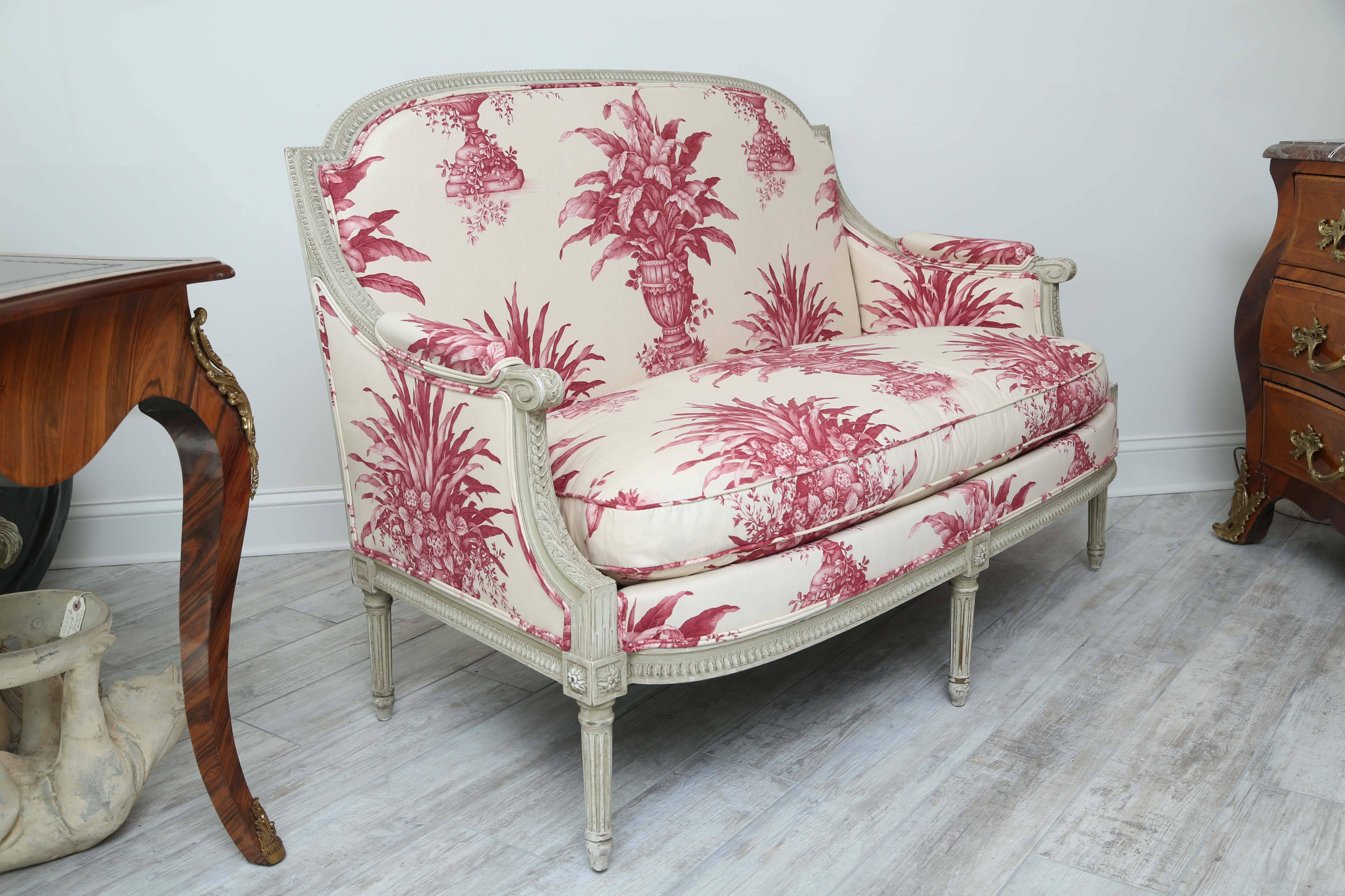 Stunning Louis XVI style loveseat newly upholstered in beautiful cream and cherry topiary fabric.