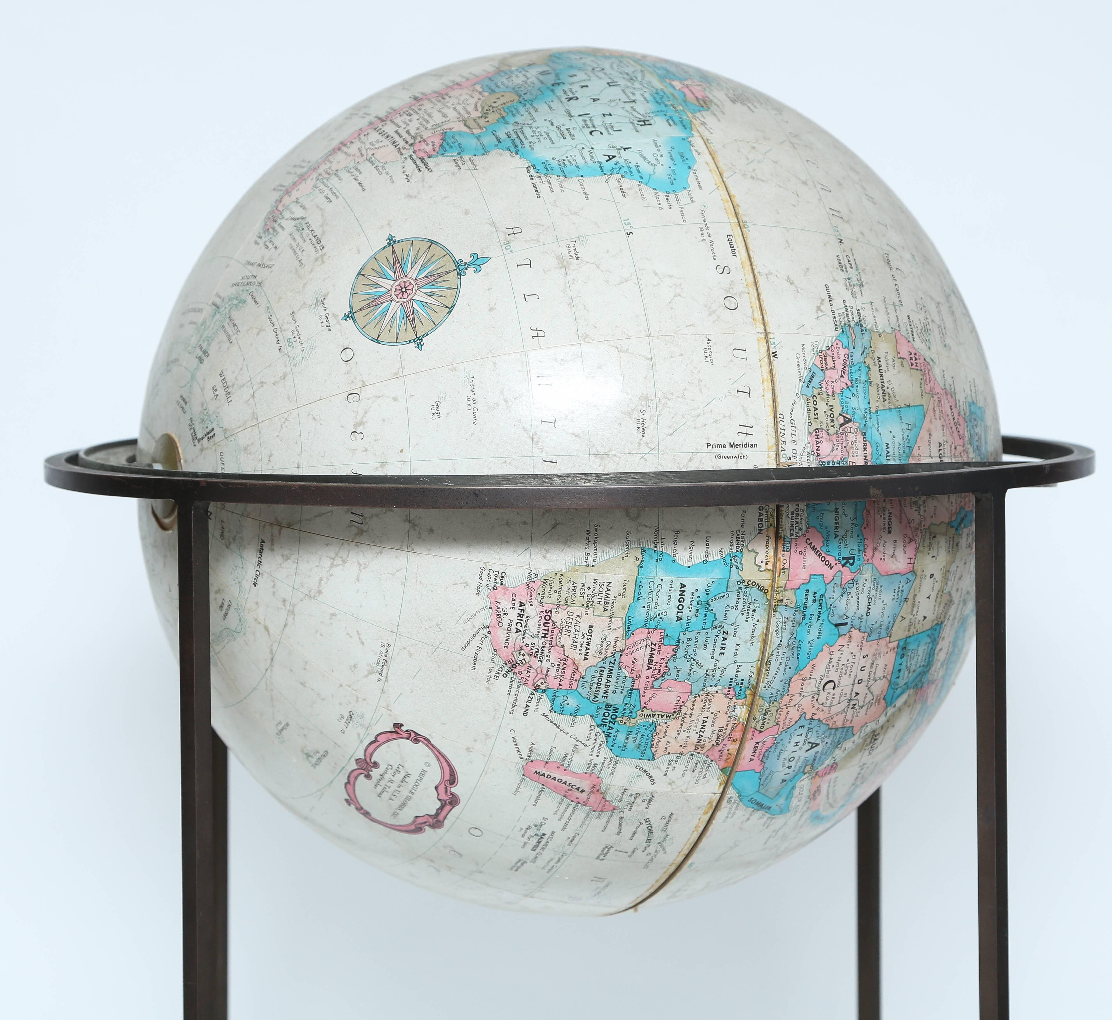 Old globe by Reploge. It tilts and pivots on its axis. Stand is constructed of brass and has a wonderful patina. This design is attributed to Paul McCobb. The actual size of globe is 16