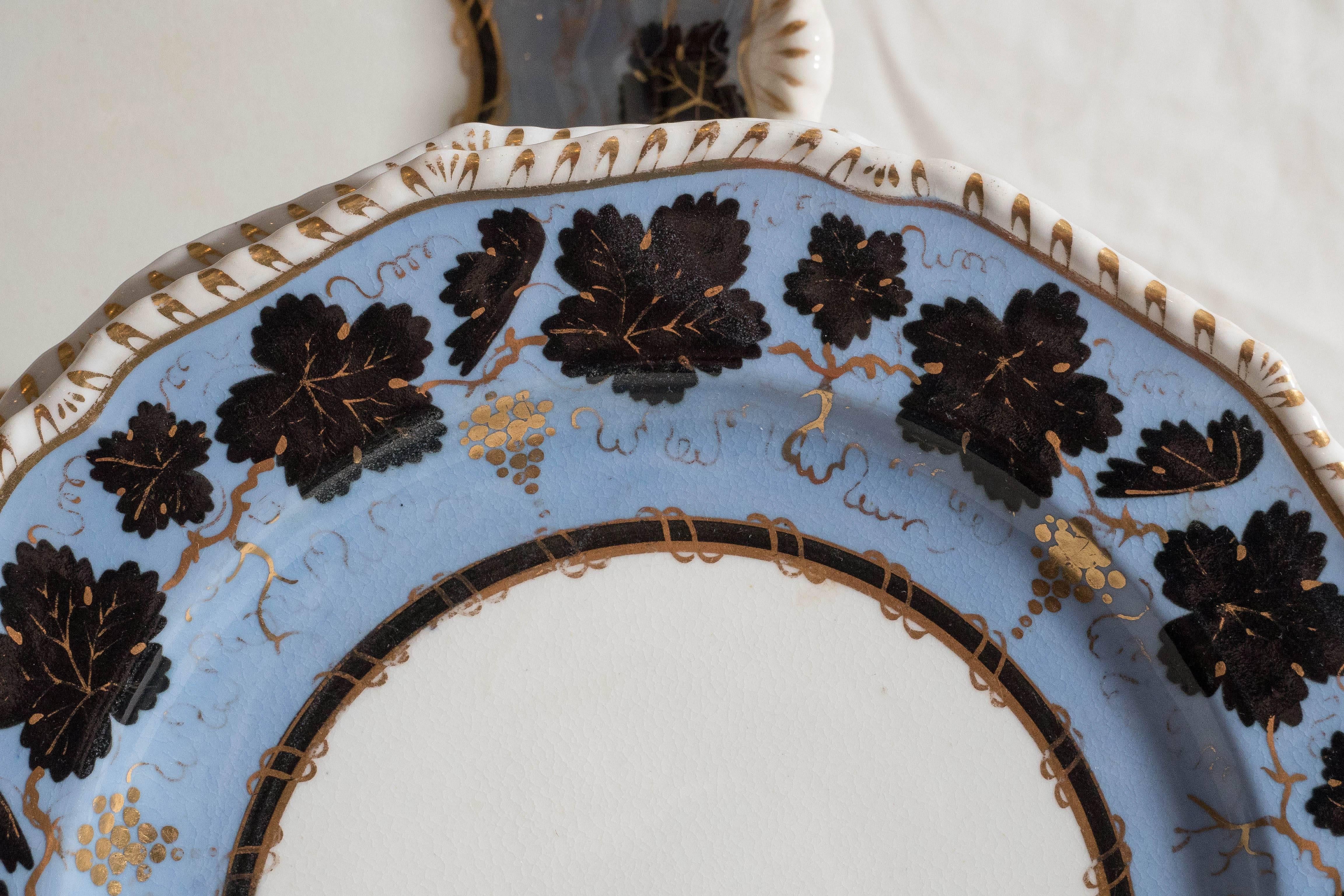 Two of the shaped dishes (the oval and one shell shape) are sold. The price of the set has been reduced accordingly.
An exquisite set of Derby Porcelain dishes painted with black leaves and gold grapes on a light blue background. The edge of the